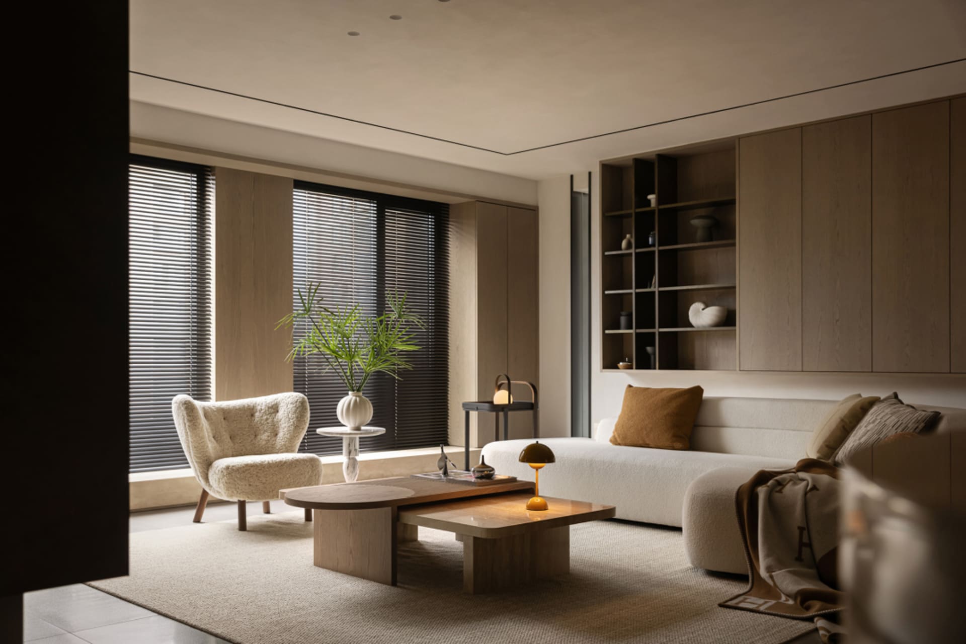 Modern minimalist living room featuring wooden furniture, fabric upholstery, and glass elements