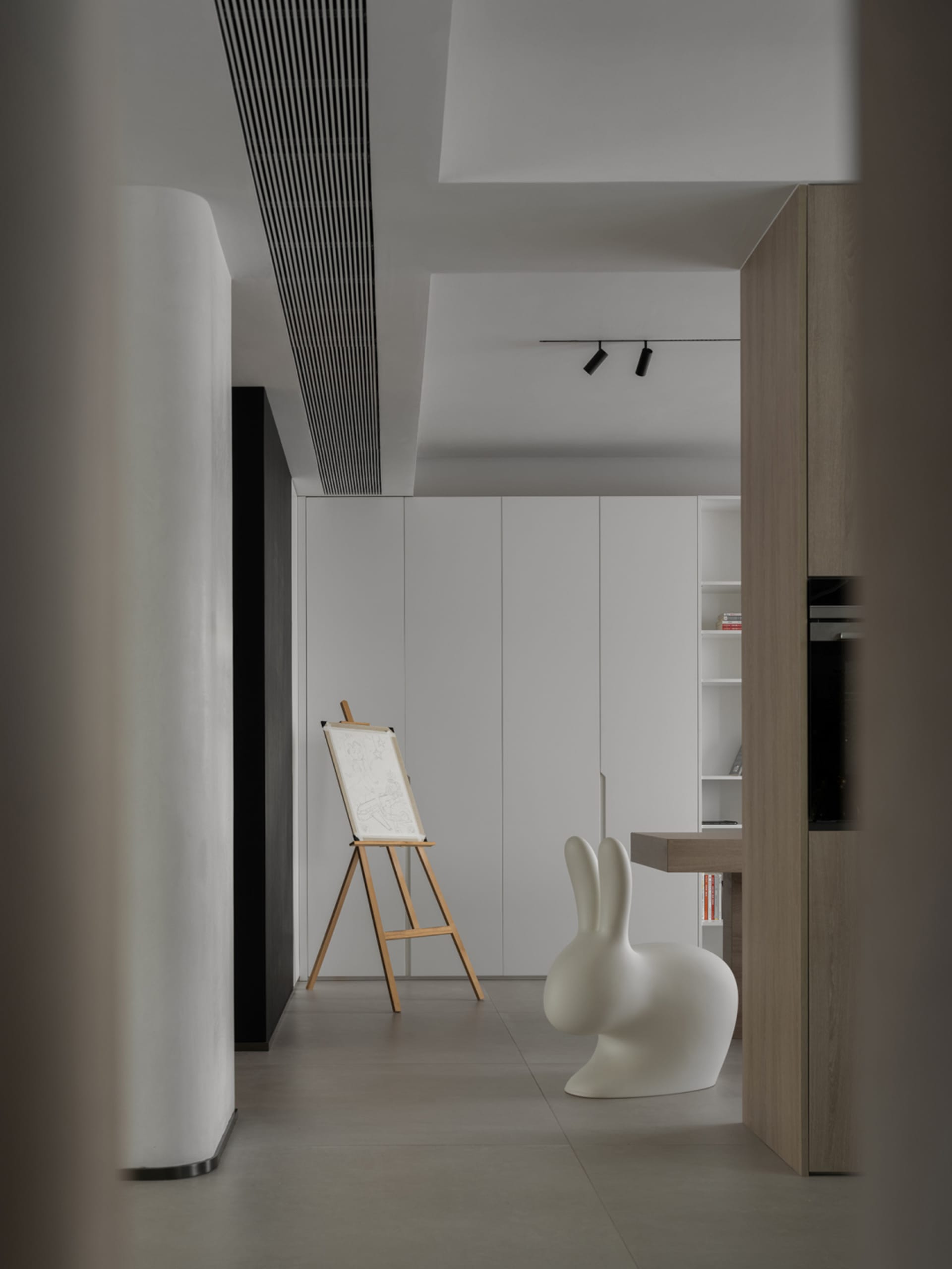 A minimalist art studio featuring a floating wooden table and white panels