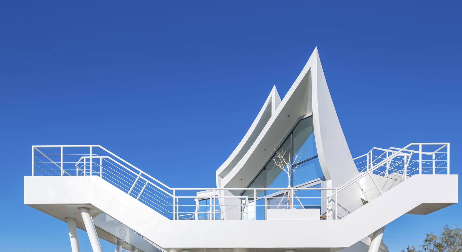 Modern minimalist house with glass walls and a geometric design.