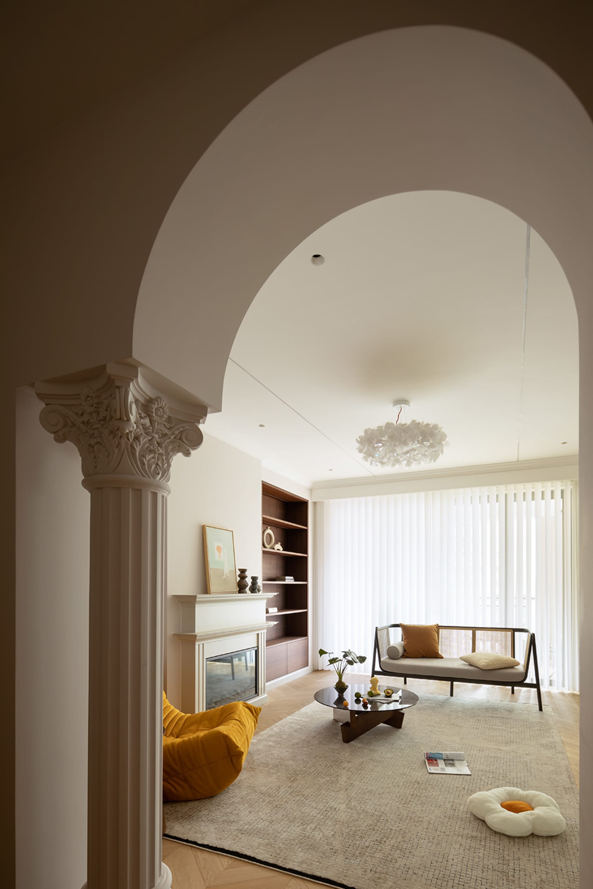 Modern living room with a neutral color palette, featuring a fireplace, a round coffee table, and a comfortable sofa.