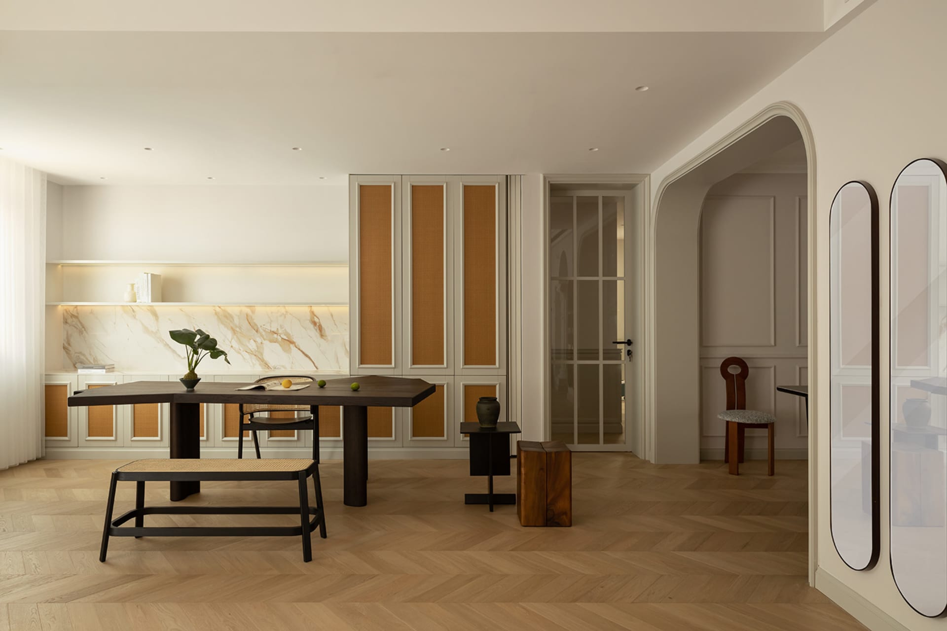 Modern residential kitchen featuring marble countertops and cane furniture.