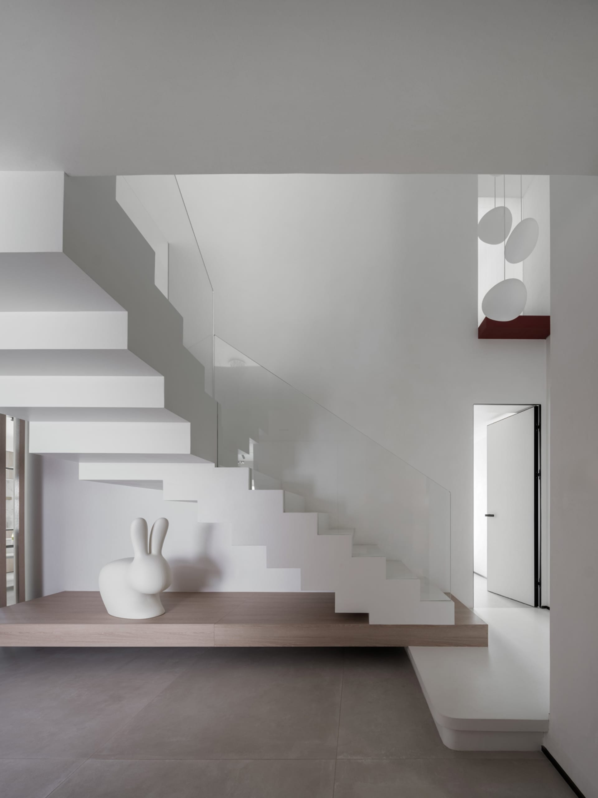 Modern minimalist interior featuring wood, concrete, and glass materials.