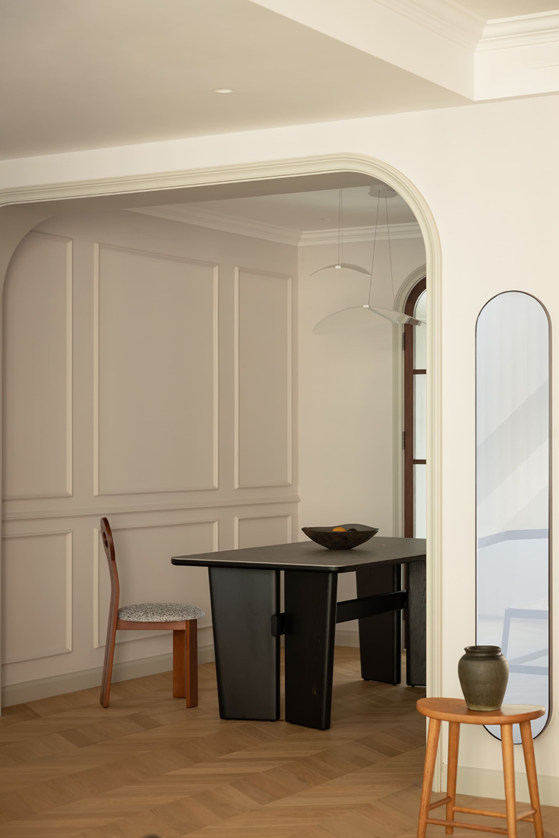 Modern interior design featuring a dining room with wood elements, including a table, chairs, and vase.