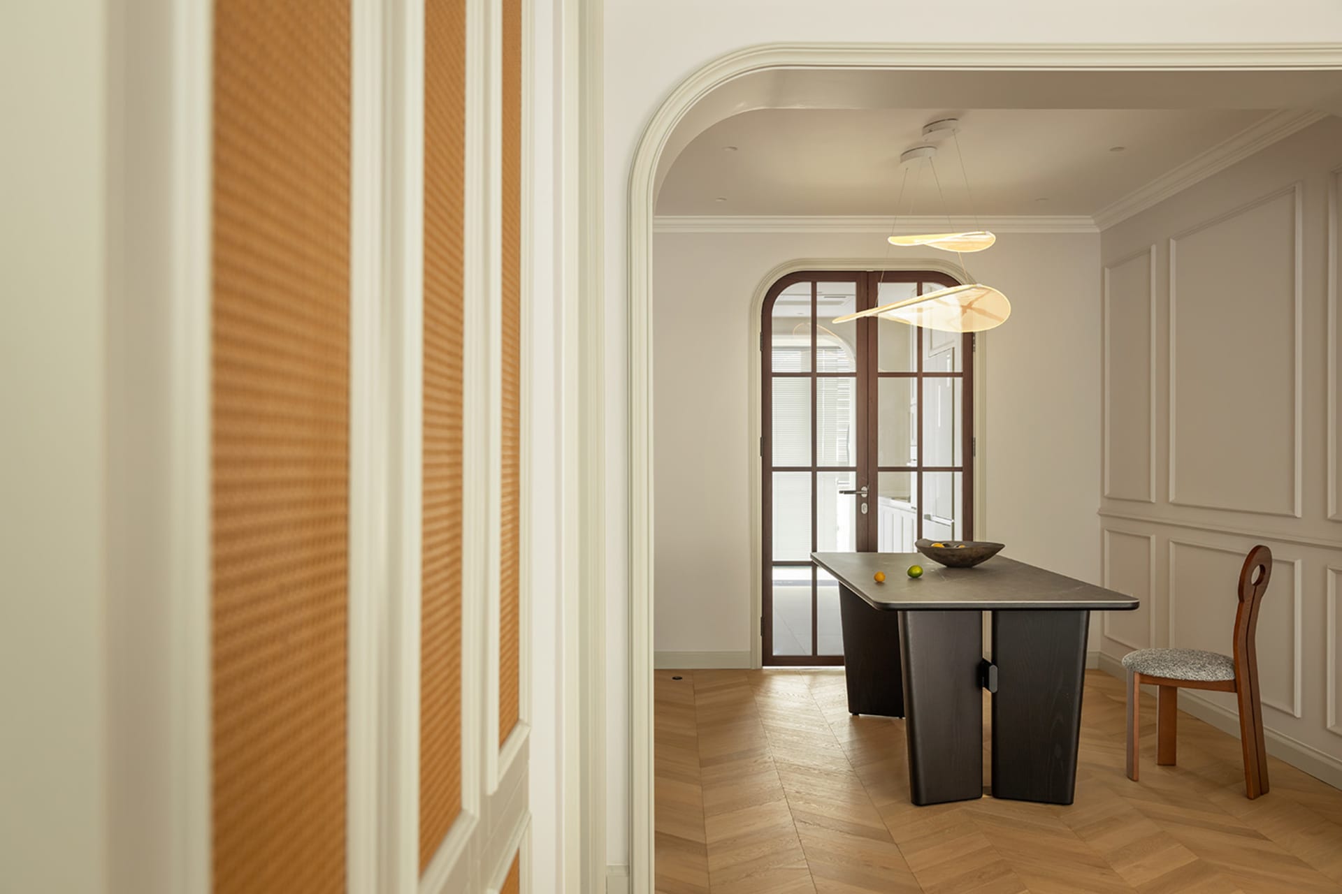 Modern minimalist dining room with wooden and metallic elements.