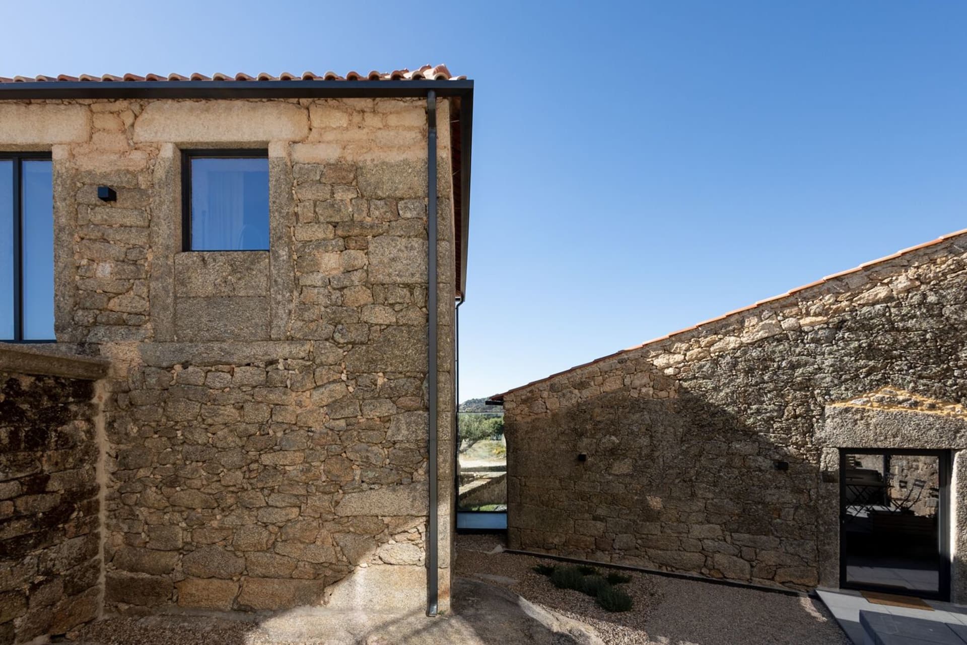 Modern residential interior with stone walls and large windows.