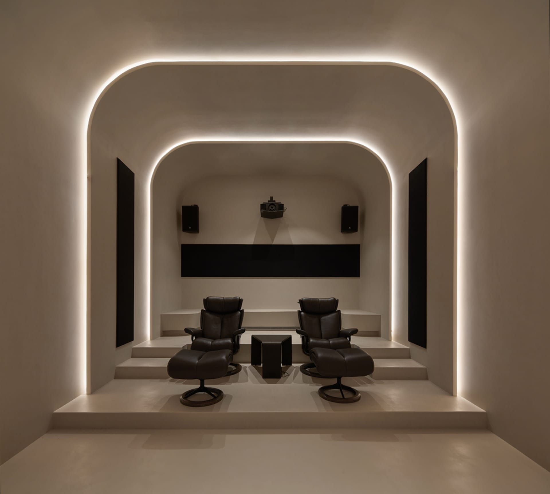 A modern home theater with industrial design elements, featuring leather recliners, concrete steps, and metal accents.