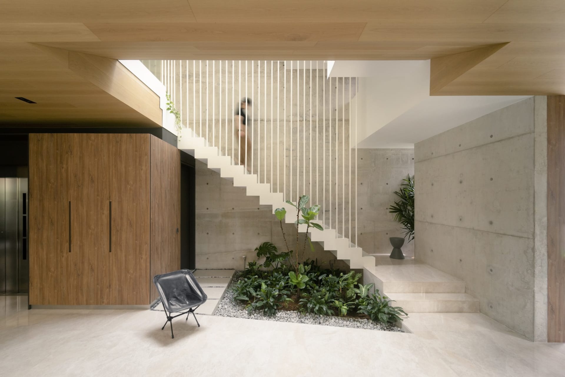 Modern interior with concrete walls and stairs, white marble stairs with plants and rocks