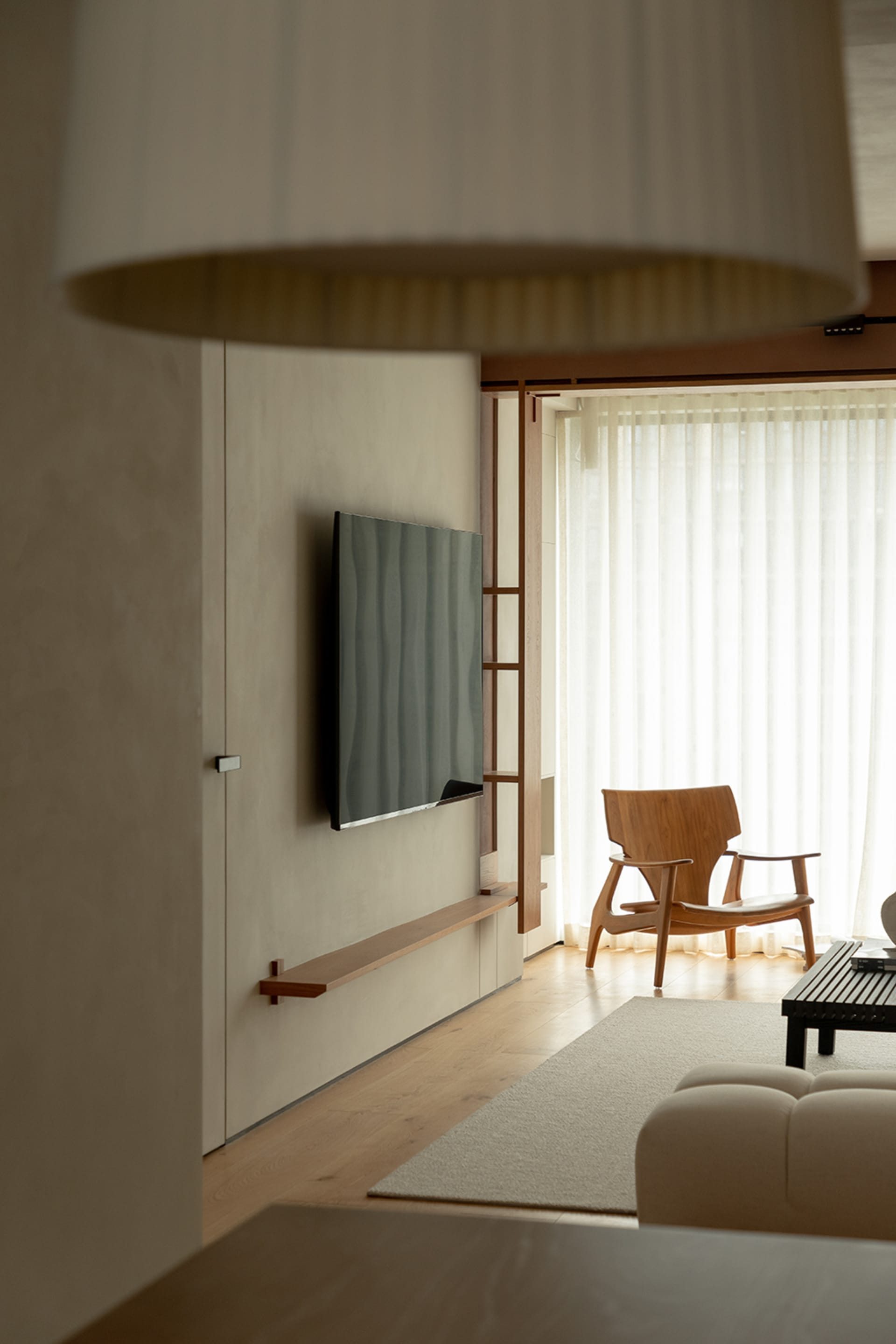 A modern minimalist living room featuring wooden furniture and minimalistic decor.