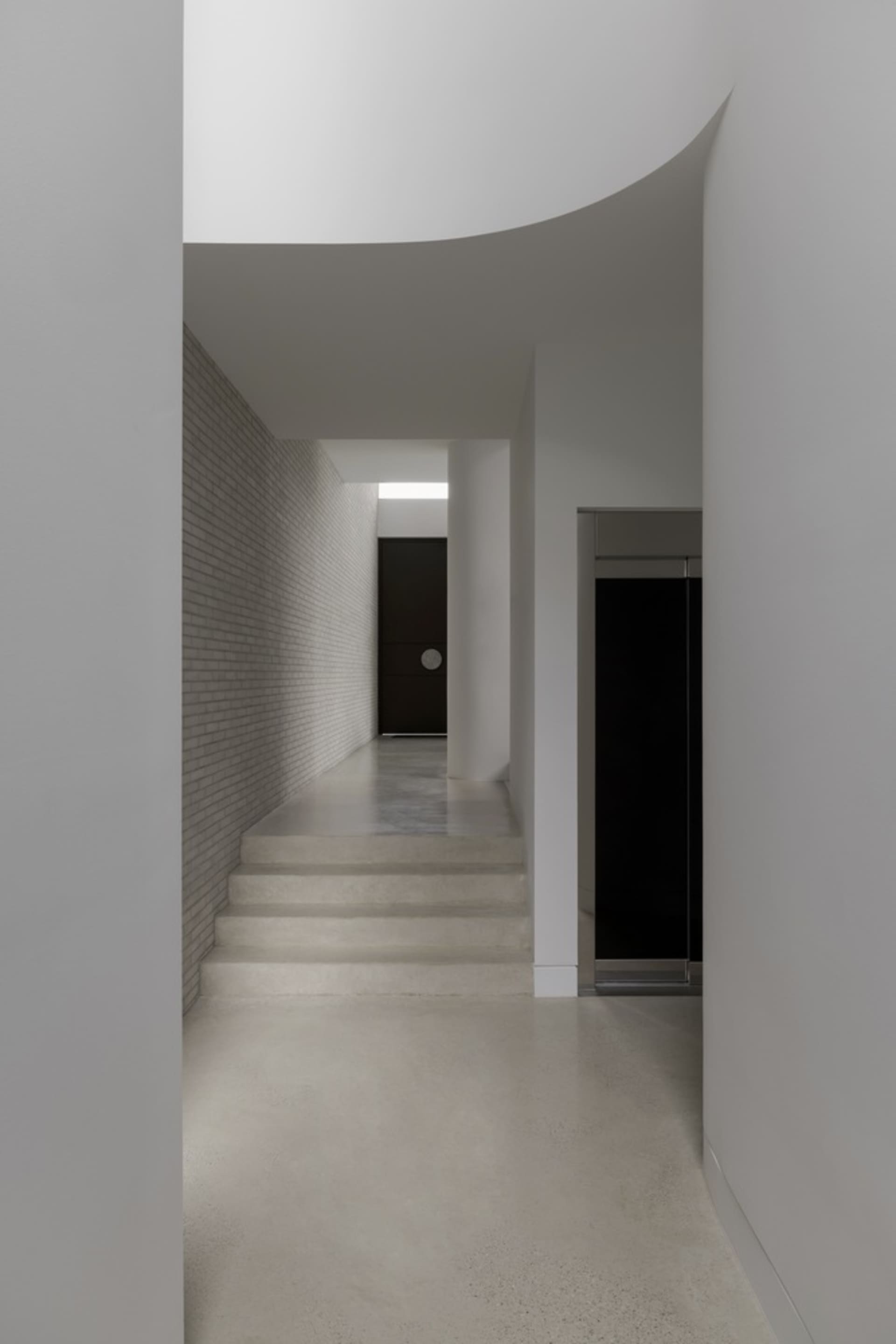 Modern hallway with concrete and brick walls and floors.