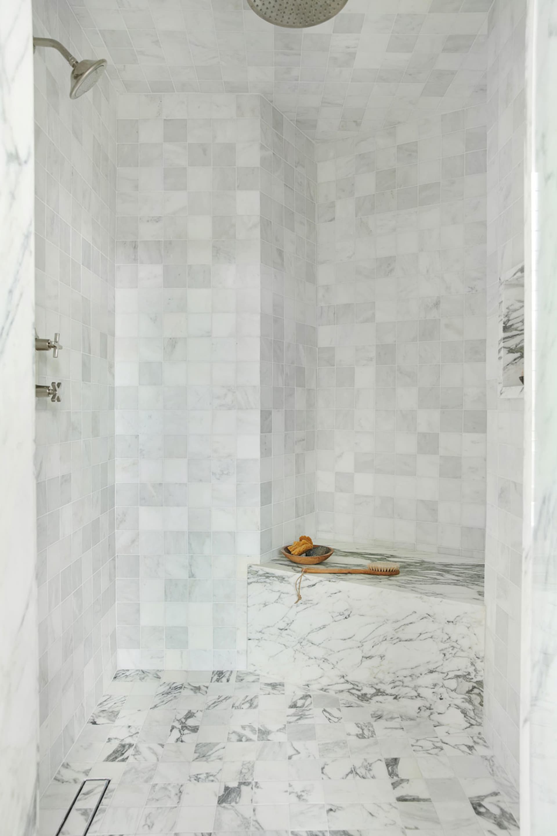 A modern minimalist marble bathroom with marble tiles on the walls and floor.