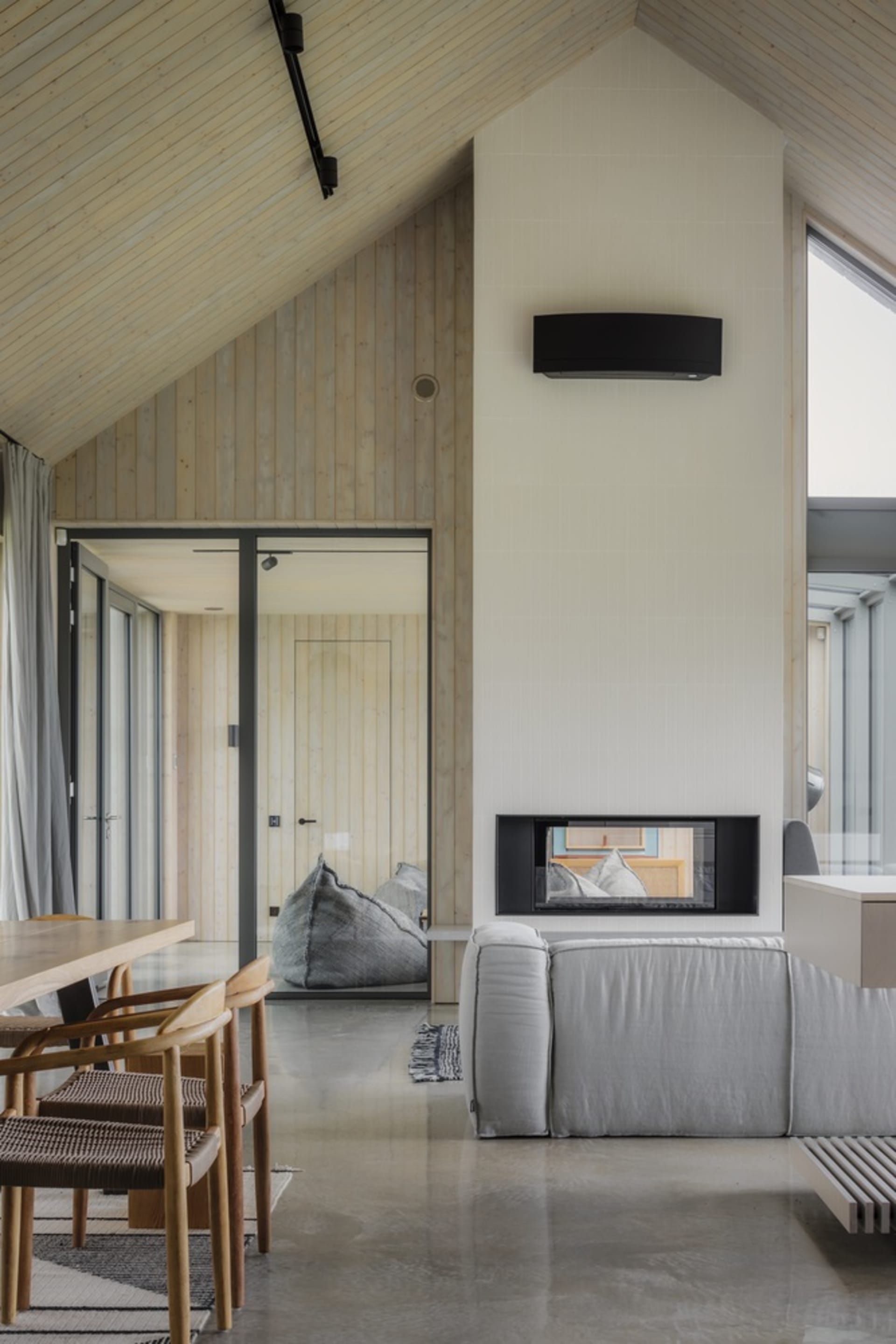 A modern minimalist living room featuring concrete and wood materials.