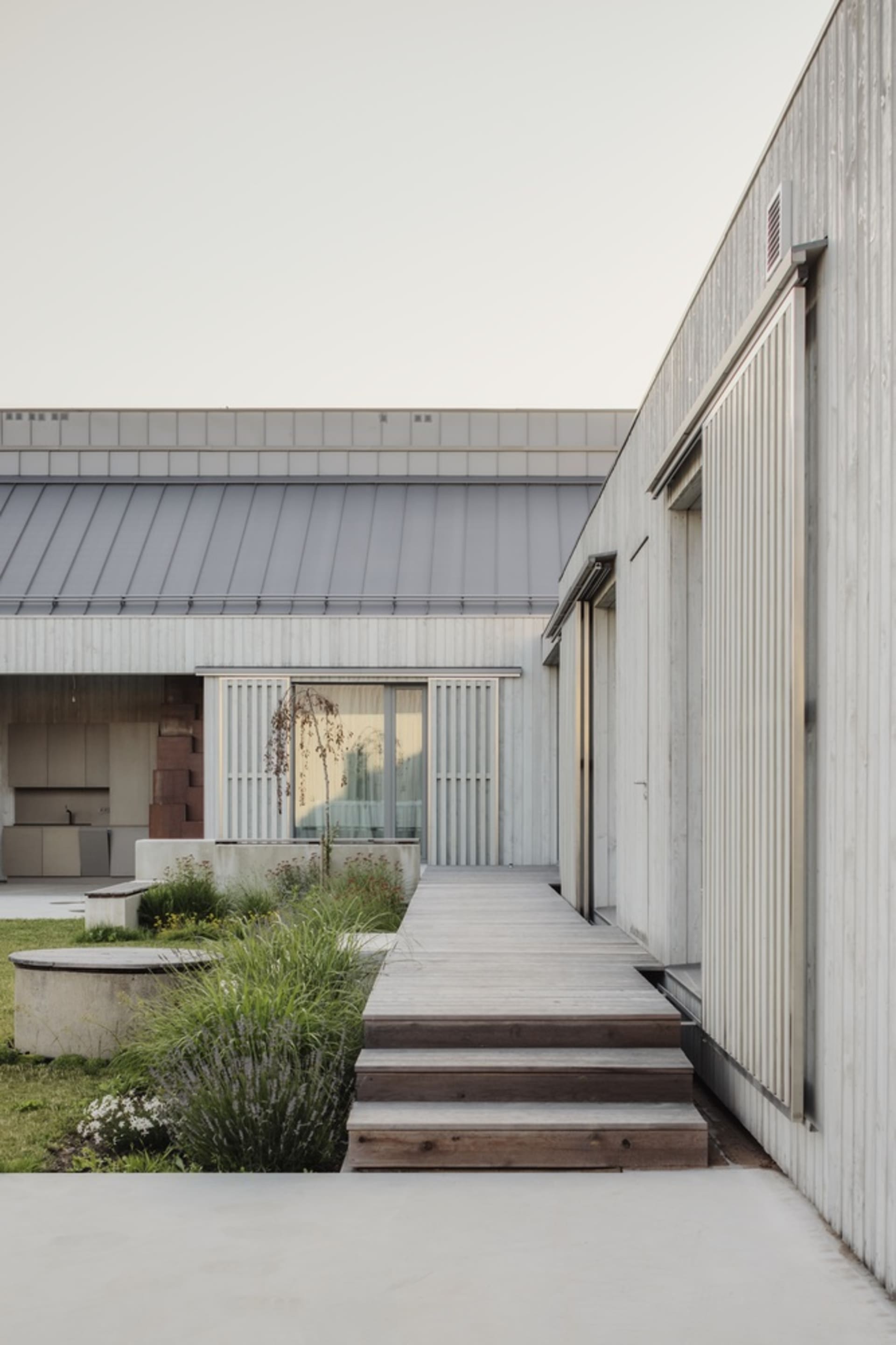 Modern residential exterior featuring wood and concrete materials