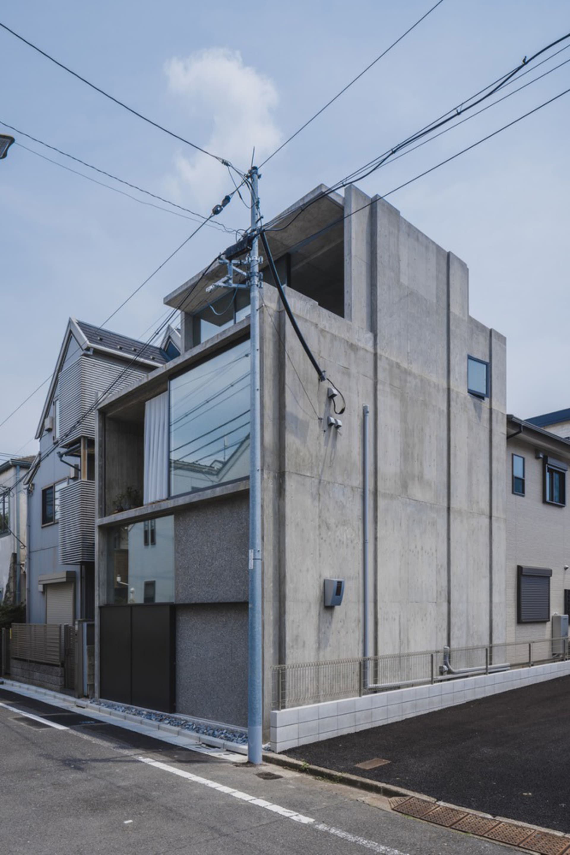 A minimalist, modern building constructed primarily of concrete, featuring clean lines and a sleek design.