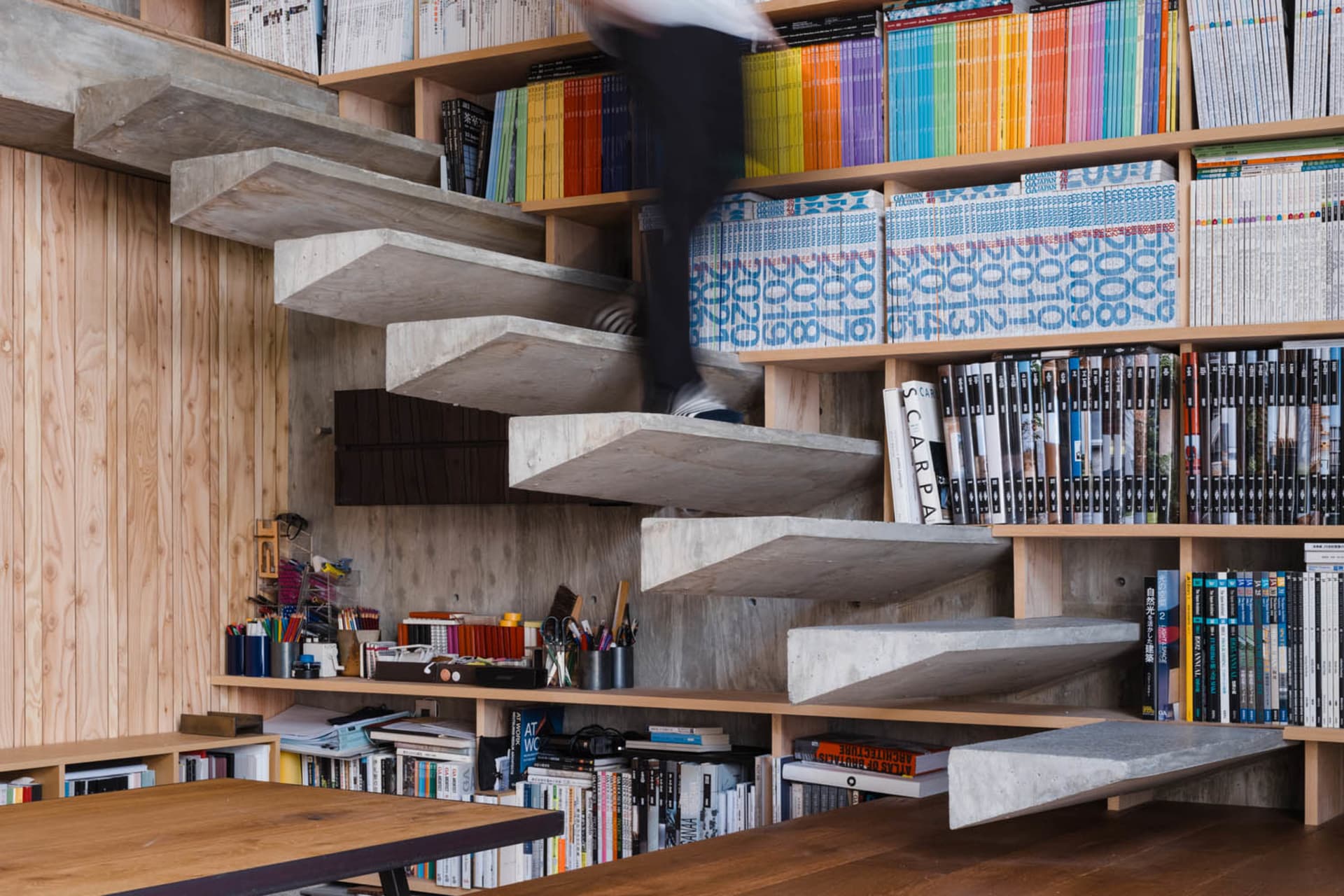Concrete shelves with books and stationery in a modern interior setting