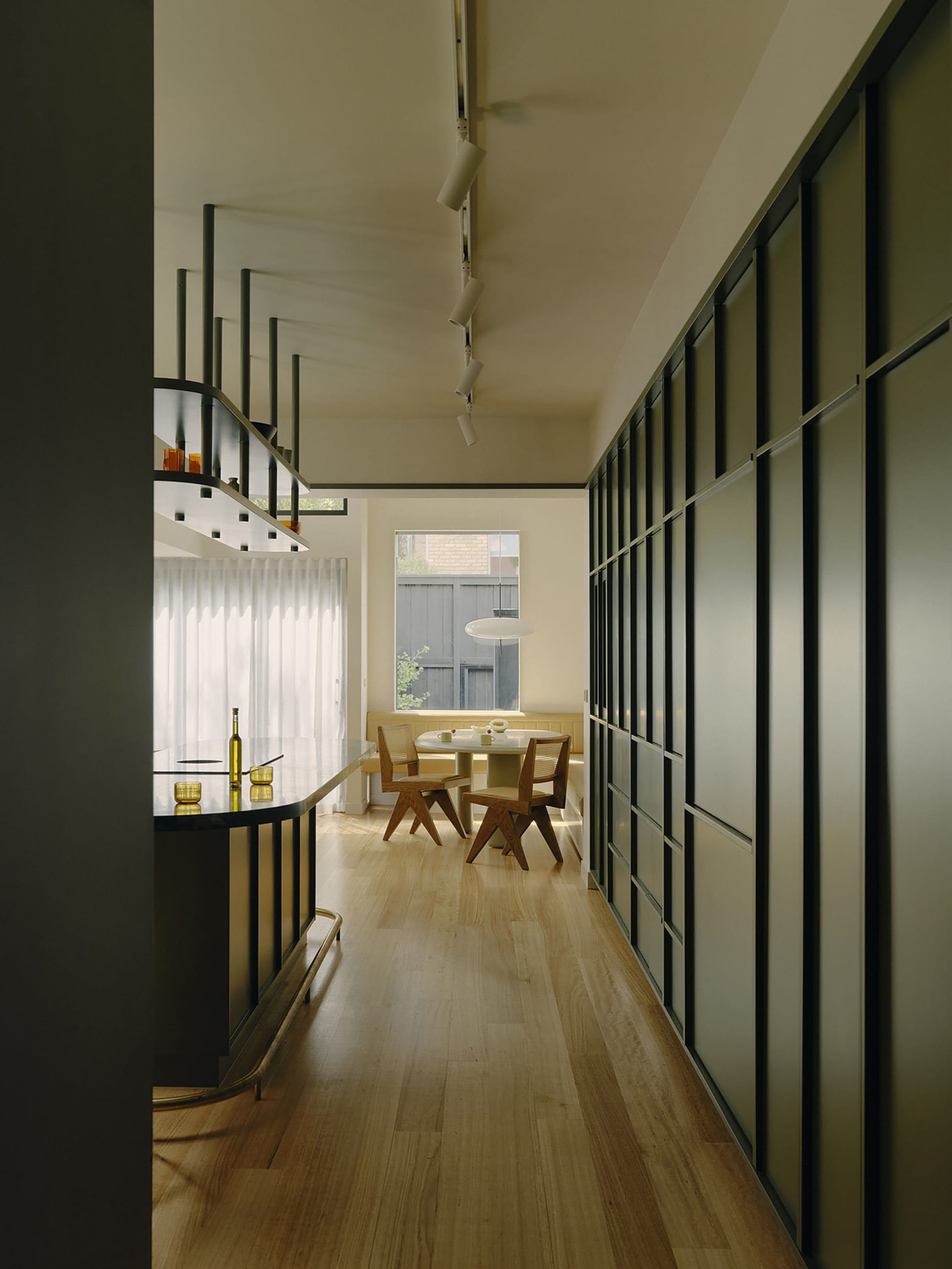 Modern interior with glass windows, wooden flooring, and metal railings.