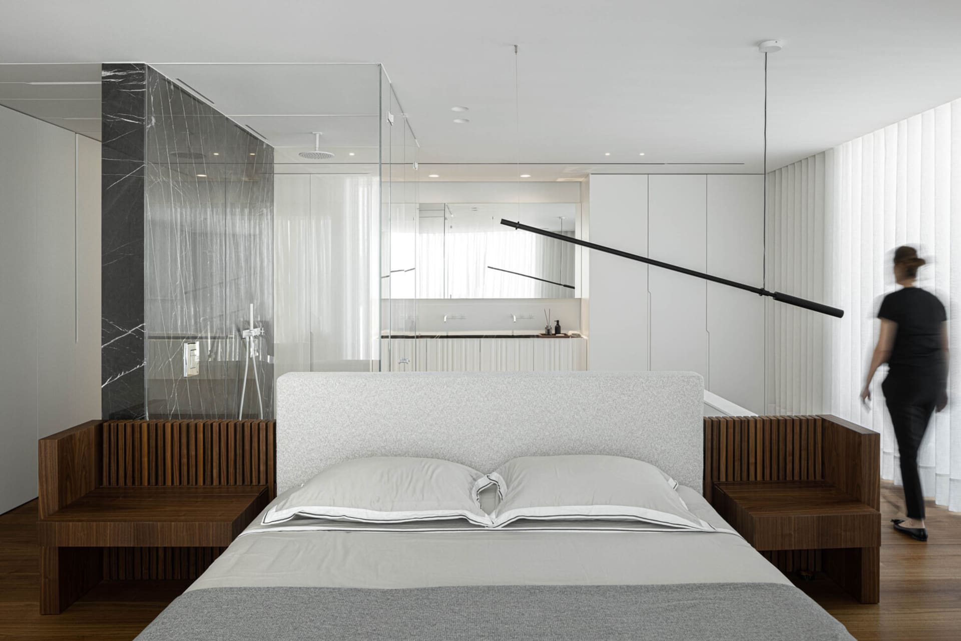 modern minimalist bedroom with white walls, wood headboard, and marble accents