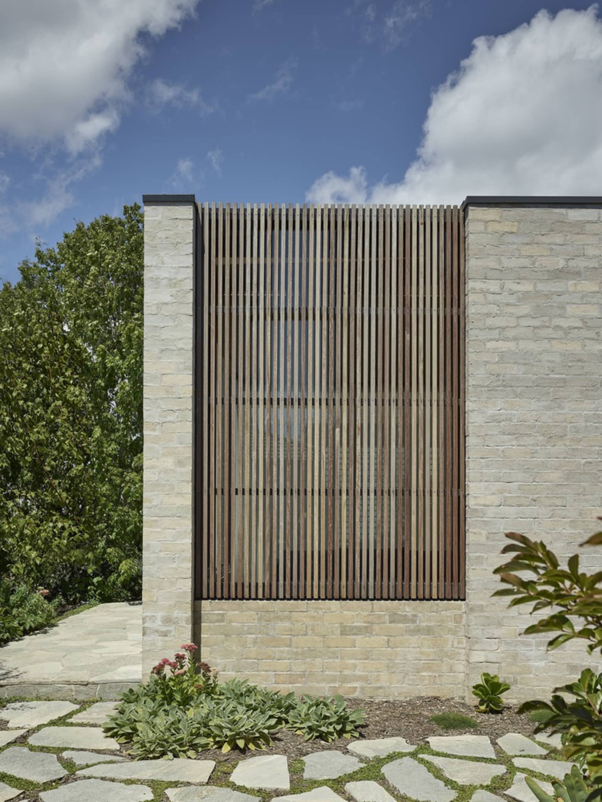 Modern exterior of a building with a brick wall and lattice window