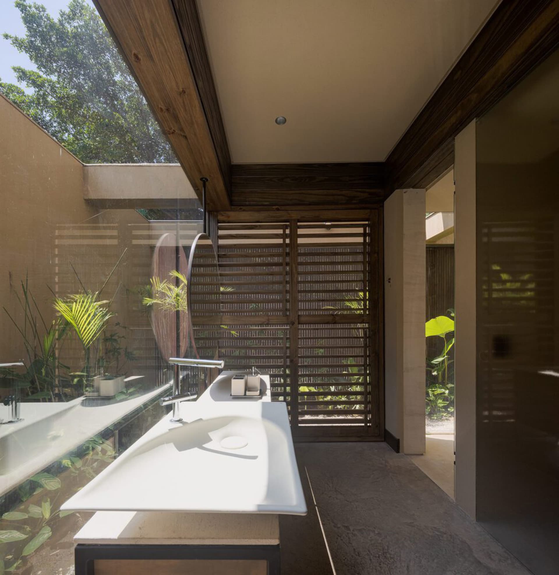 A modern bathroom featuring a sleek, white floating sink with a concrete countertop, situated in a contemporary residential s