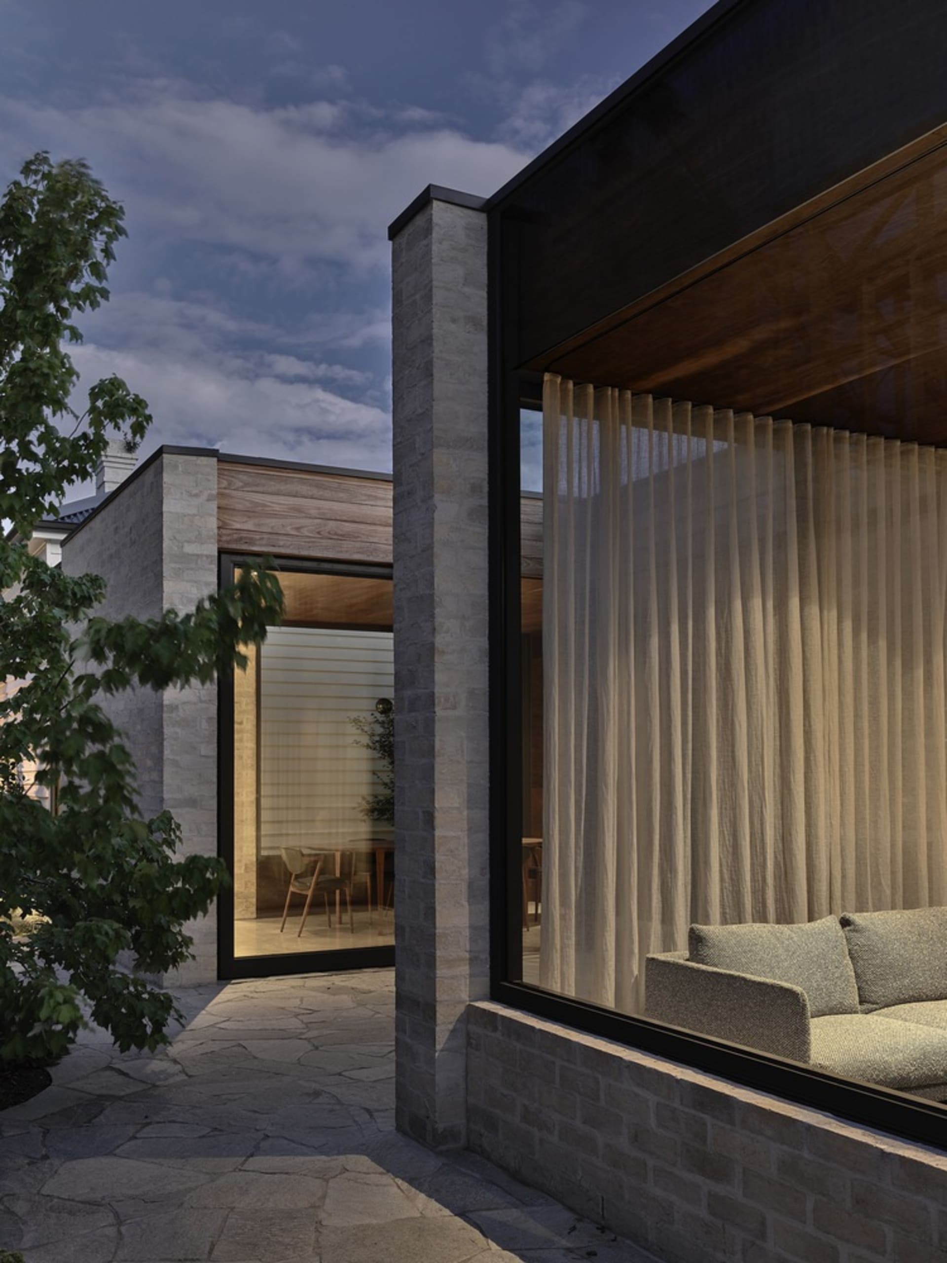 A modern exterior with stone walls and curtains.