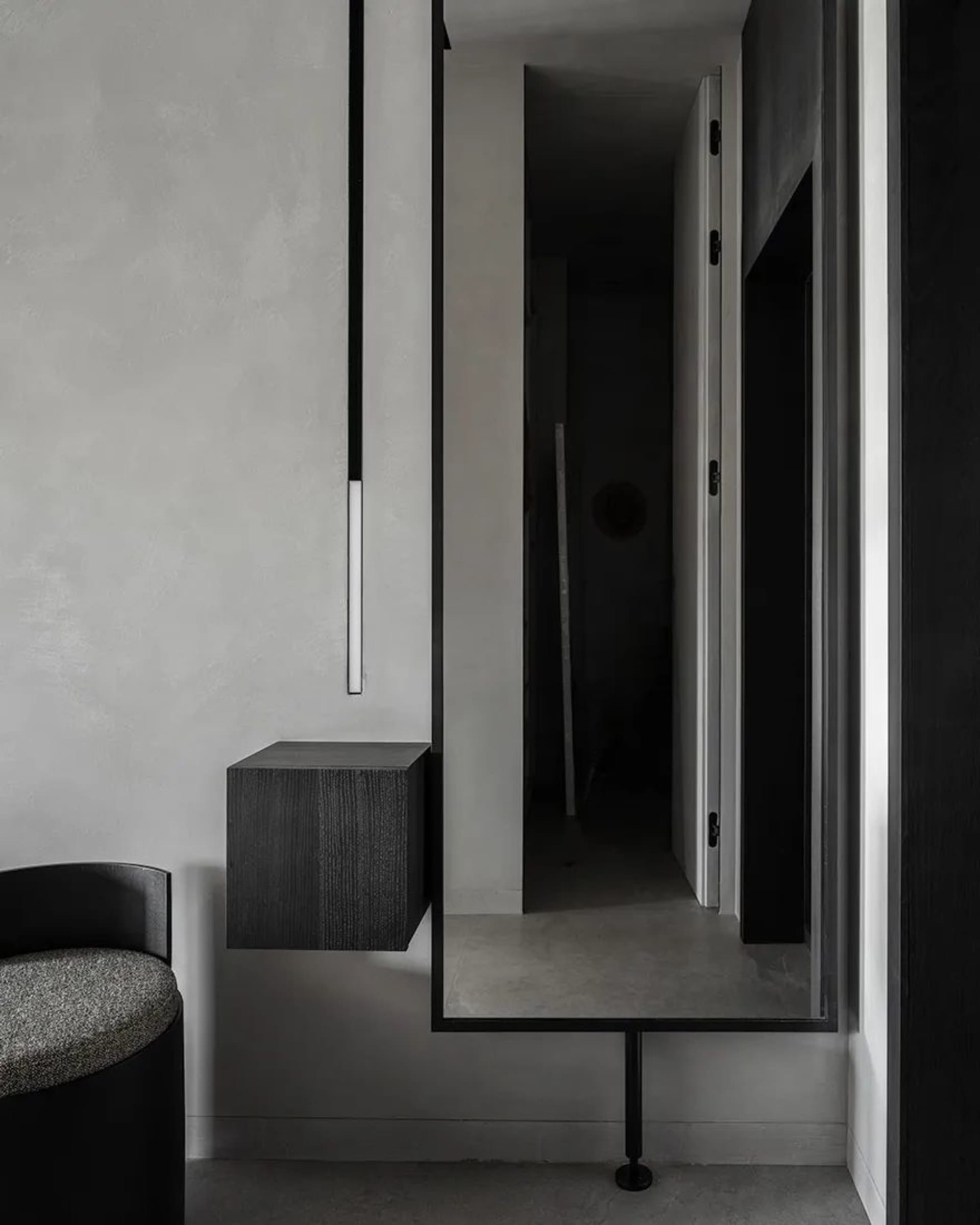 Modern interior with concrete walls, floor, and floating cabinet.