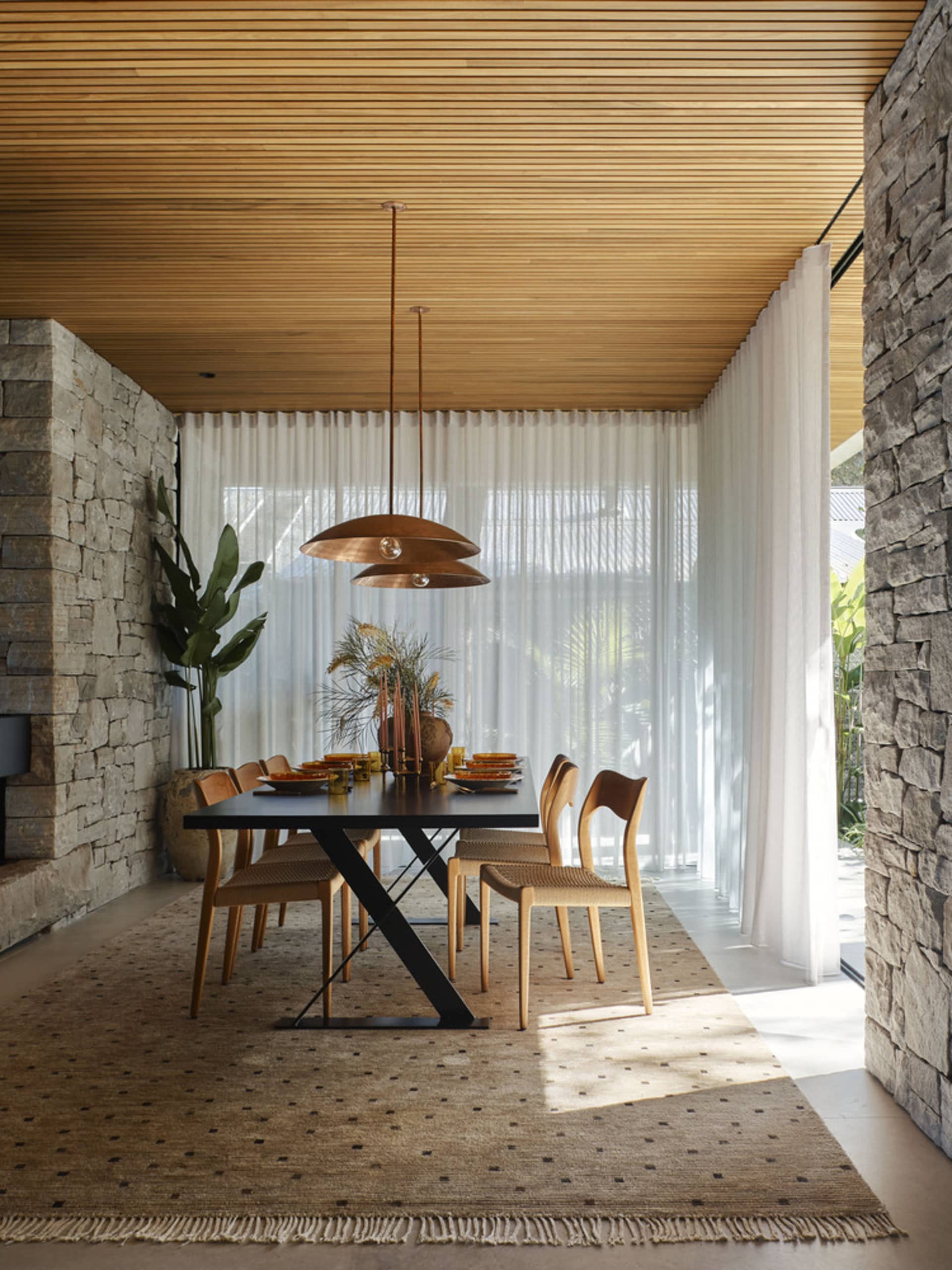 Modern dining room featuring wooden furniture, leather accents, and stone elements.