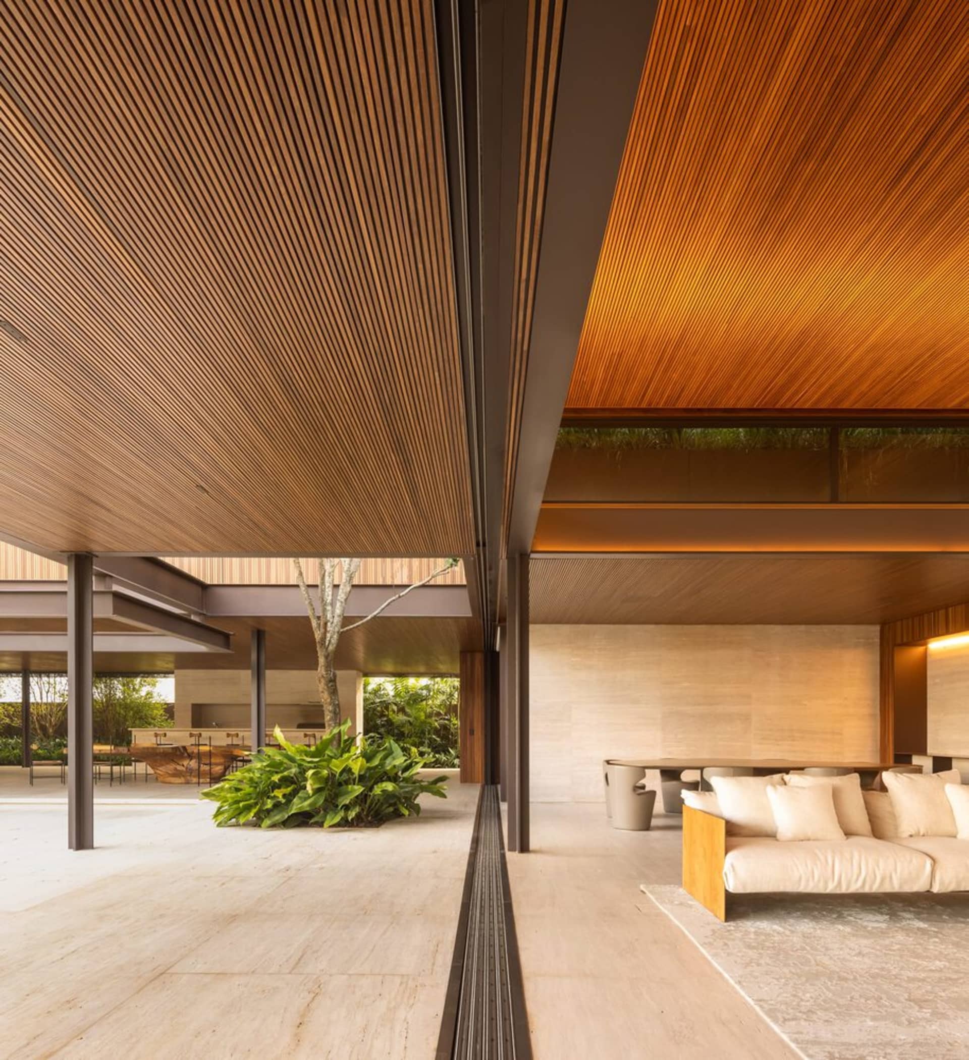 Modern living room with wooden beams, concrete floor, and indoor plant