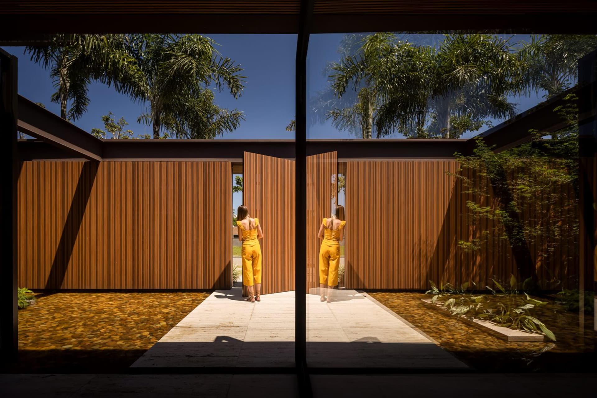 A modern architectural design featuring wooden walls and a concrete pathway.
