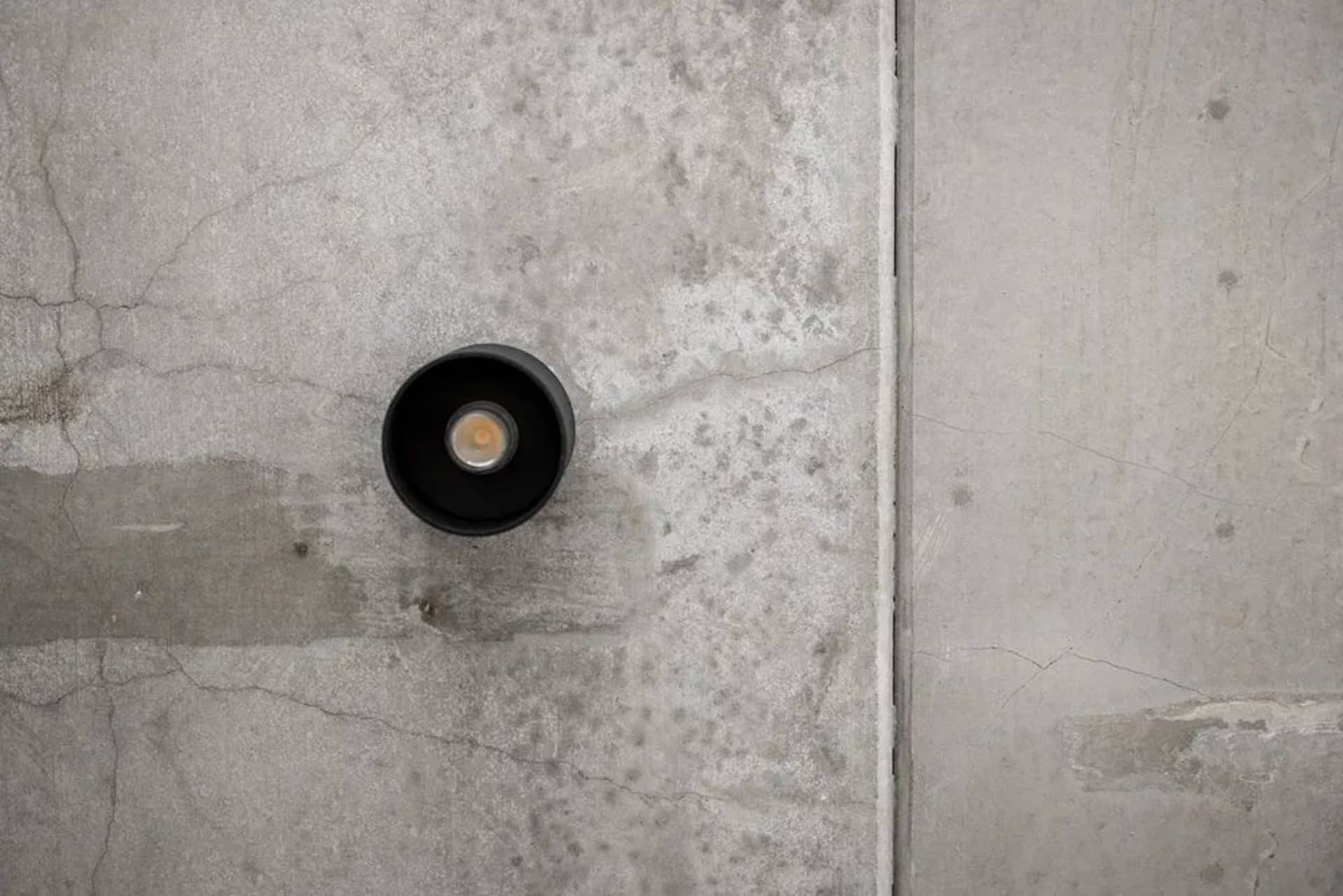 Industrial light fixture mounted on a concrete wall.