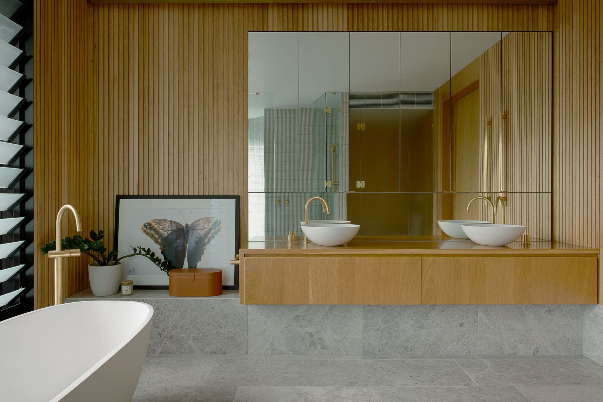 A modern bathroom featuring wooden interior design elements and a contemporary sink and mirror setup.