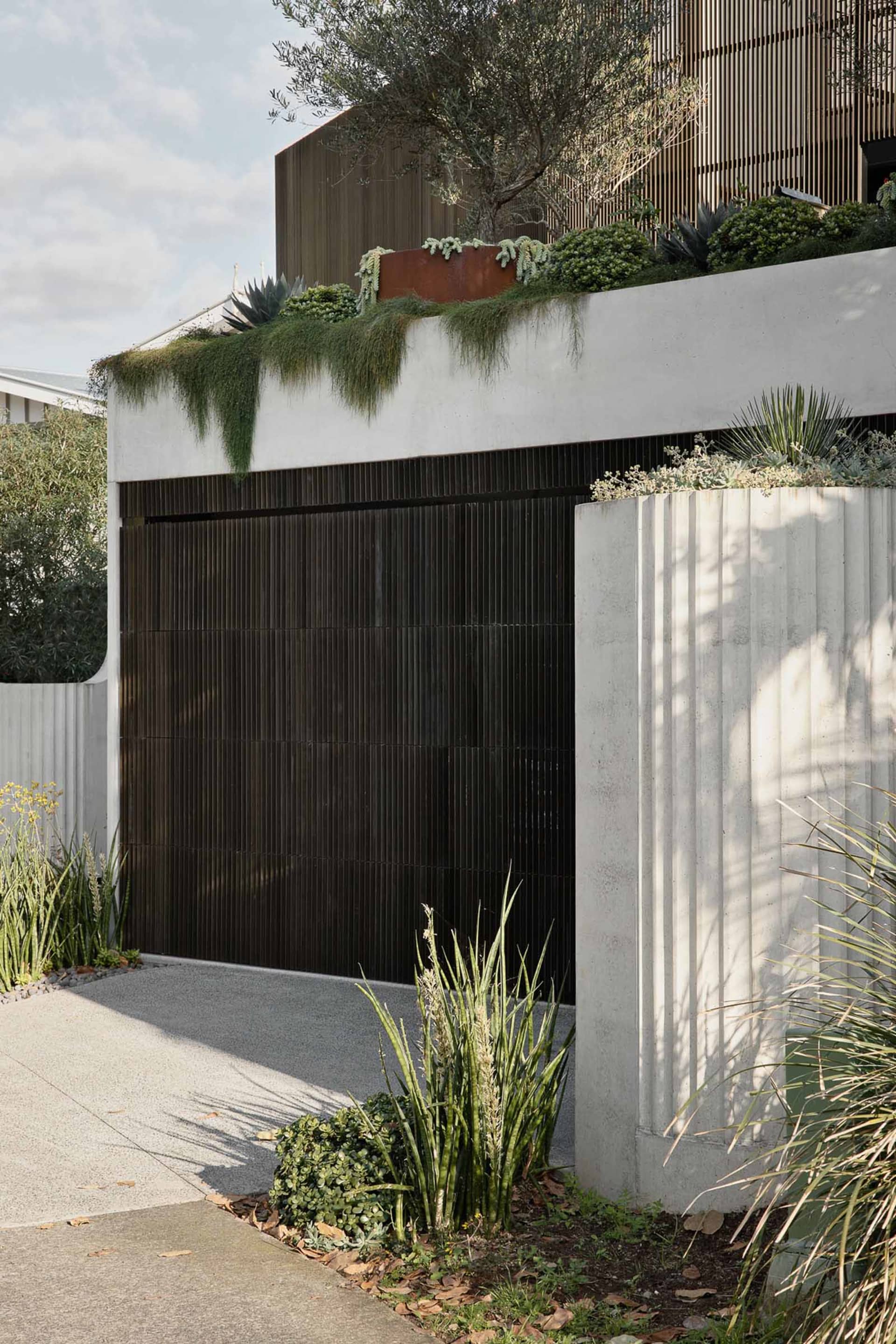 Modern house exterior with concrete walls and vehicle garage.