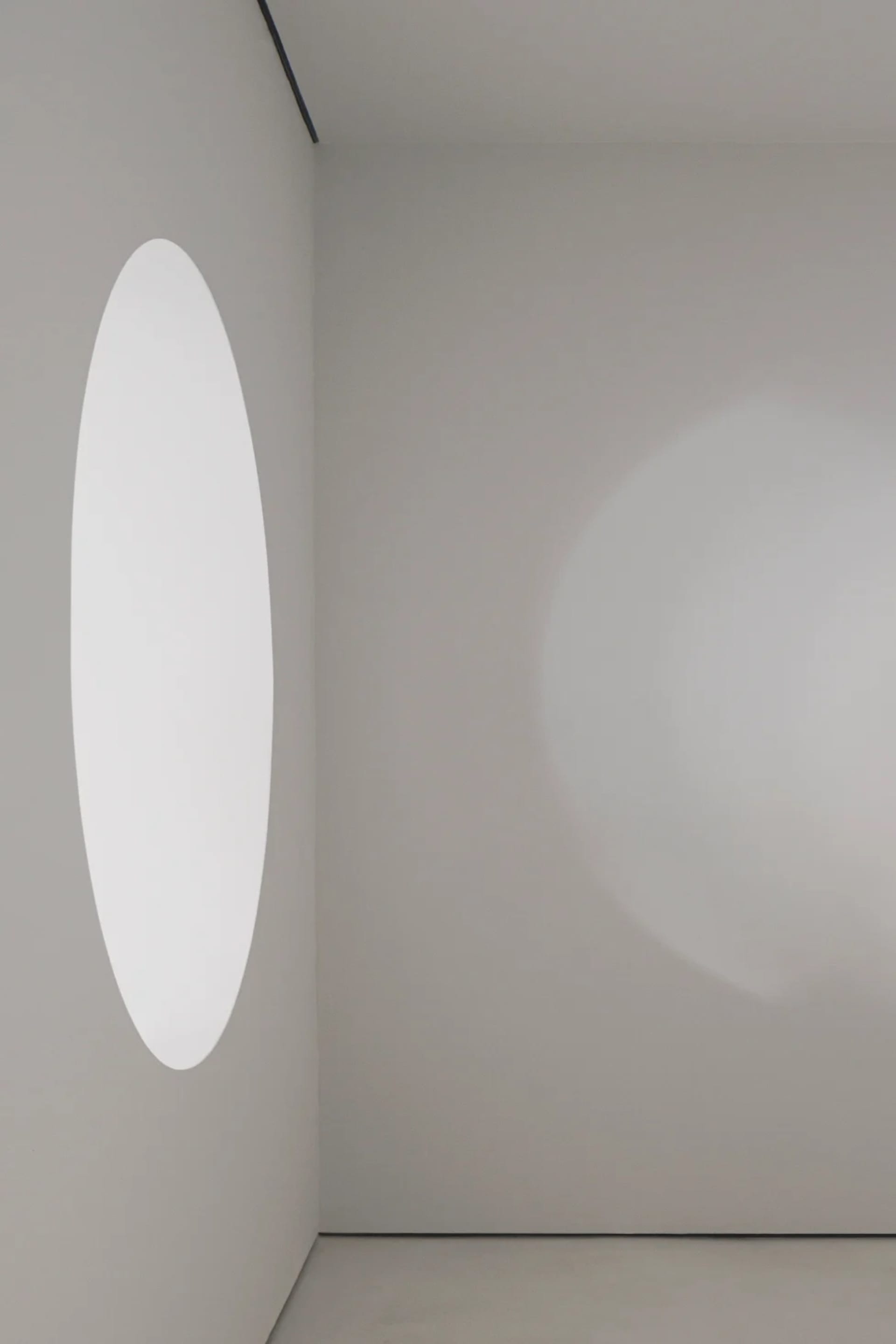 A minimalist design featuring a glass space with a circular window.