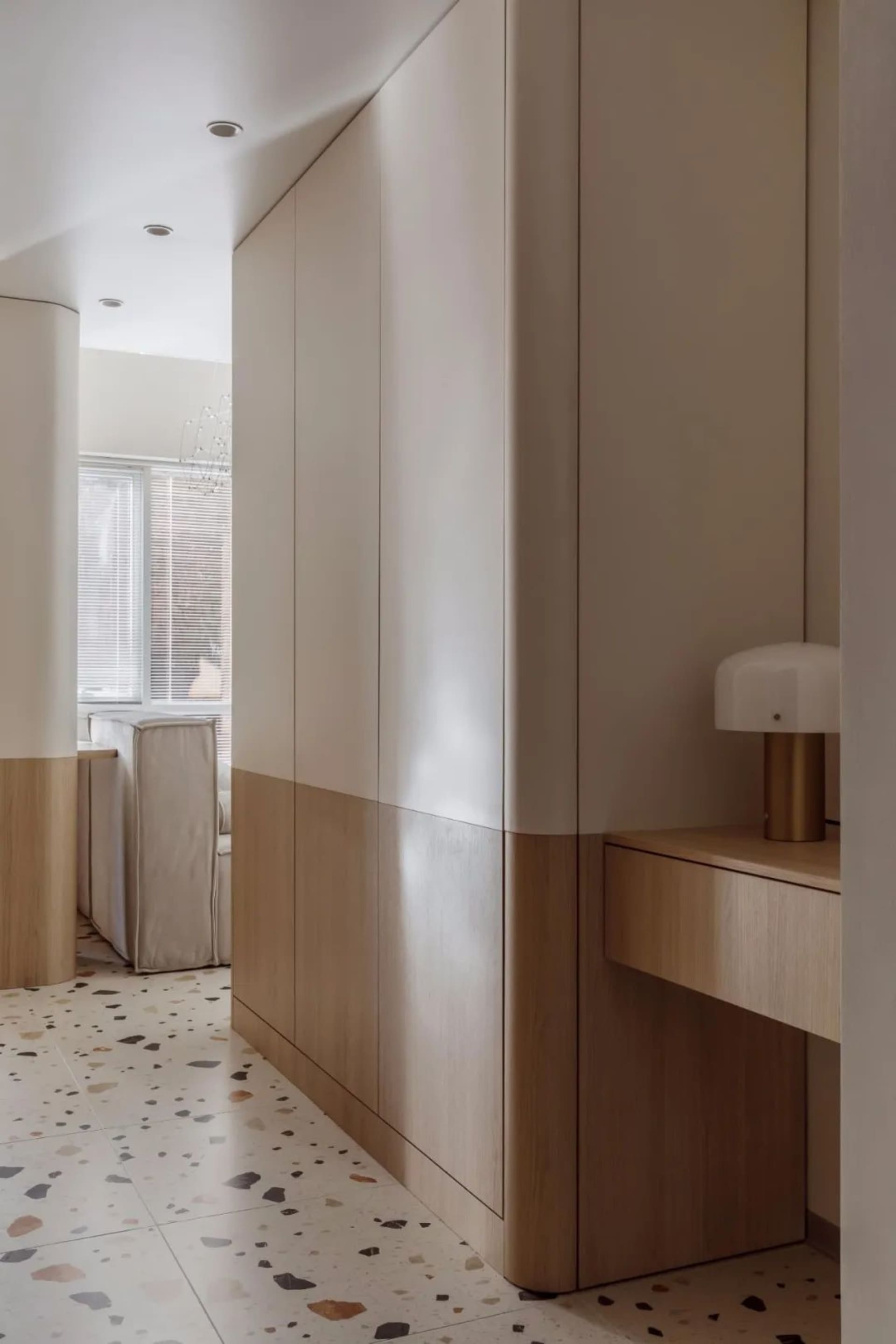 Modern minimalist apartment interior featuring natural wood materials and sleek, geometric design elements.