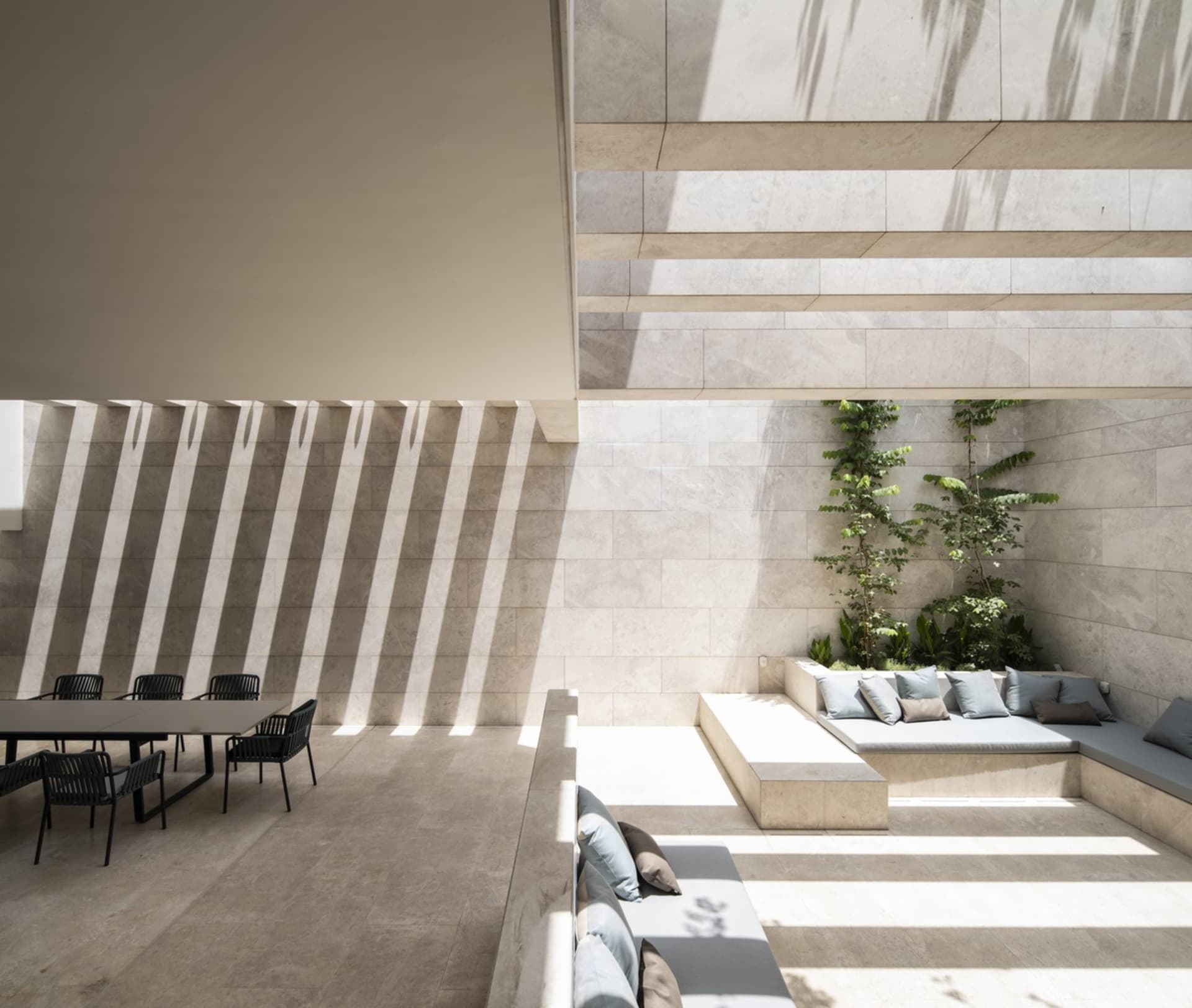 A modern minimalist living space featuring light-colored tiles and marble materials.
