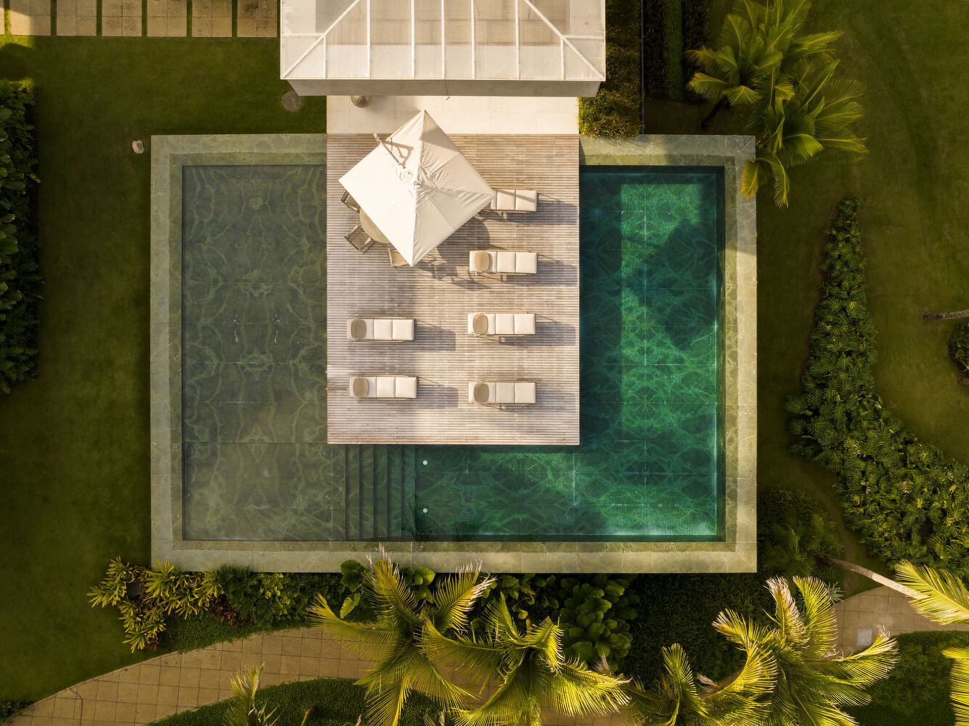 Modern residential exterior with stone, glass, and metal materials.