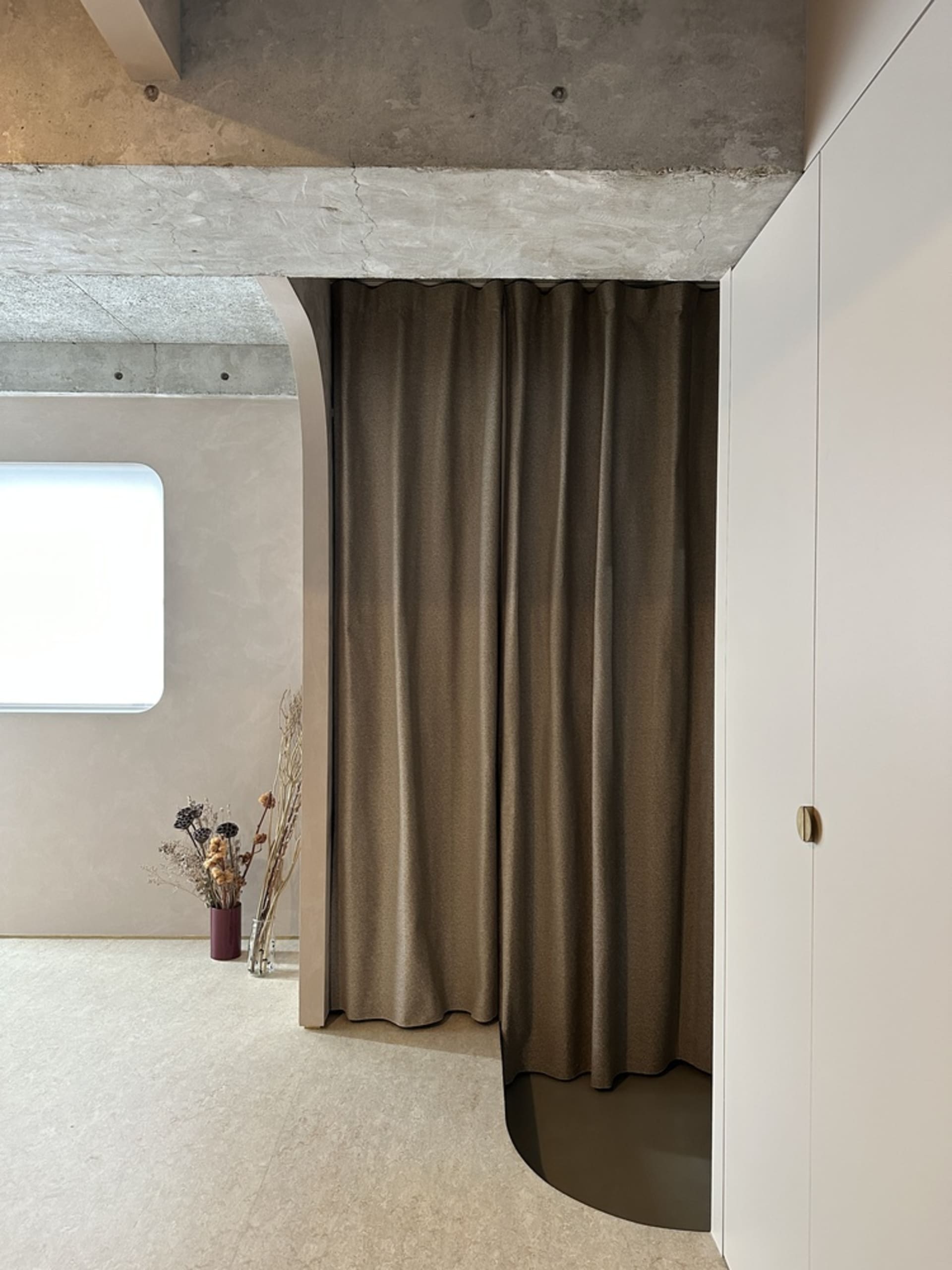 A modern residential bathroom featuring concrete walls and wooden accents.