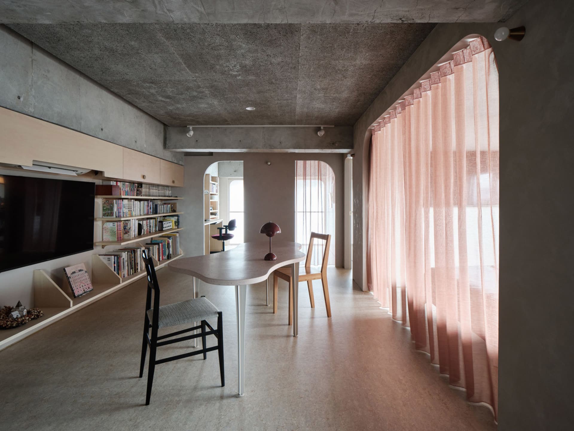 A modern home office space featuring concrete and stone materials with a large curtain for privacy.