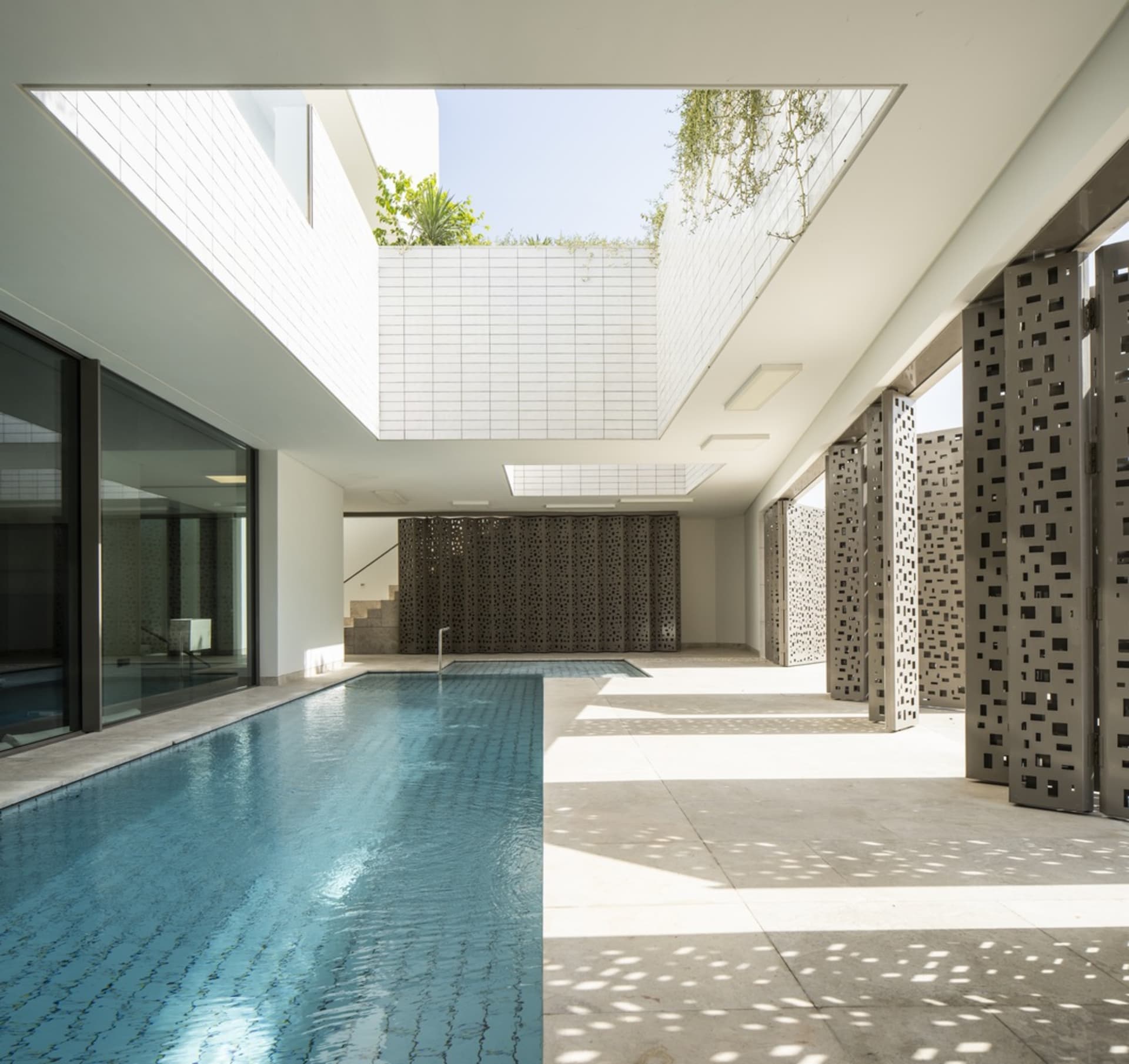 Modern residential space featuring glass walls and concrete flooring.