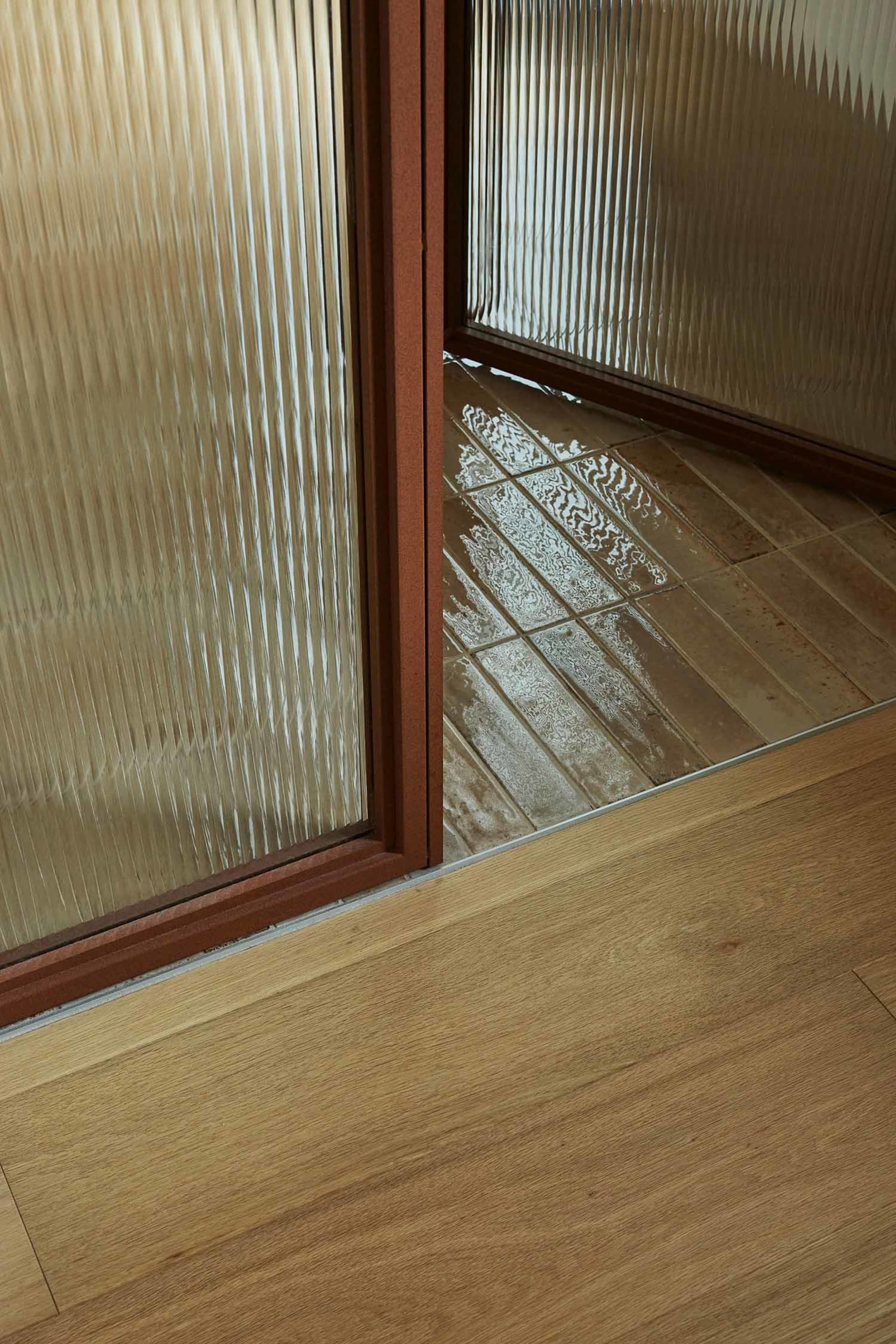 A modern bathroom interior featuring glass tiles on the walls and floor.