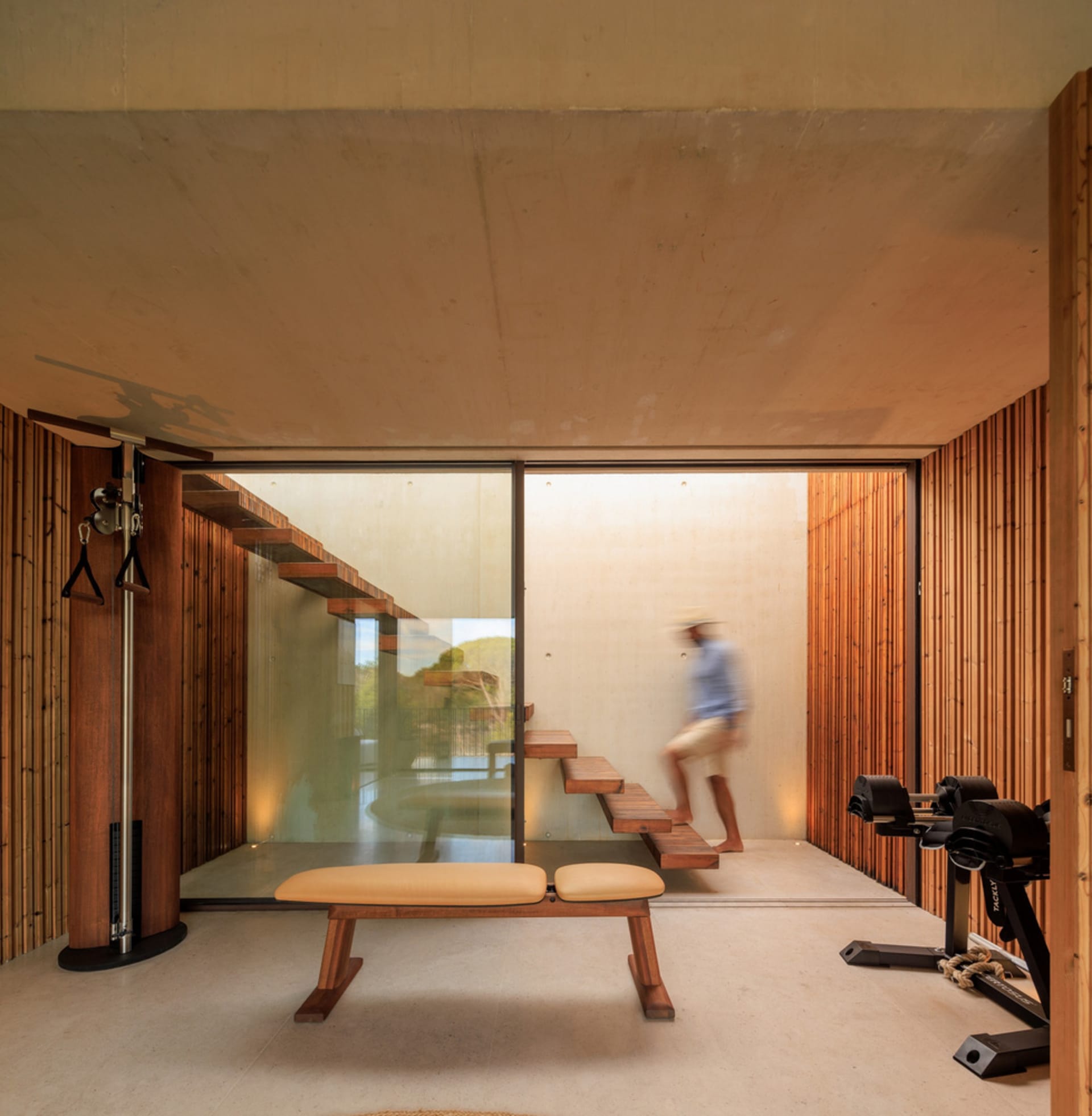 Modern industrial-style fitness studio with wooden elements and exercise equipment.