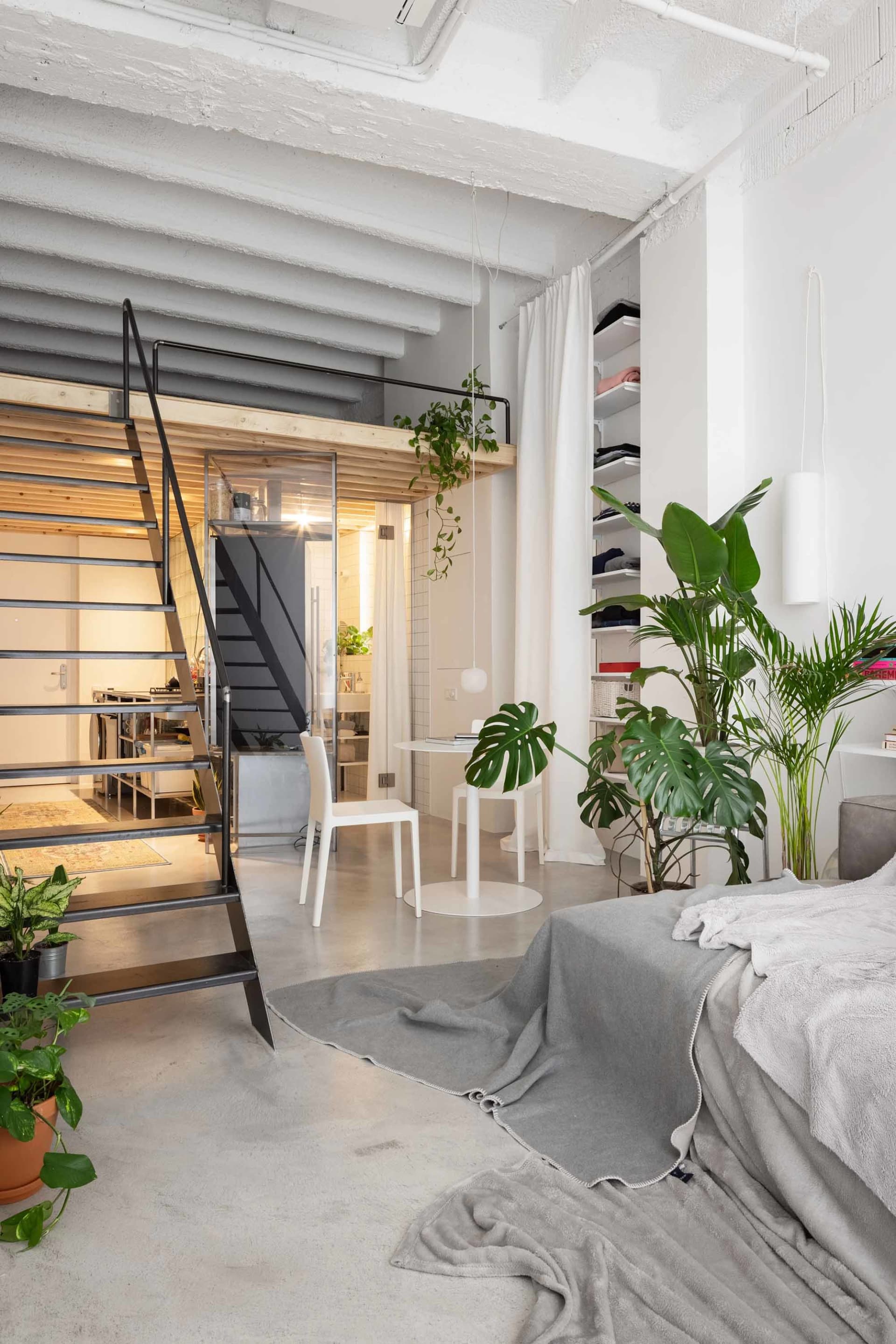 Modern industrial residential loft featuring concrete, metal, and glass elements.