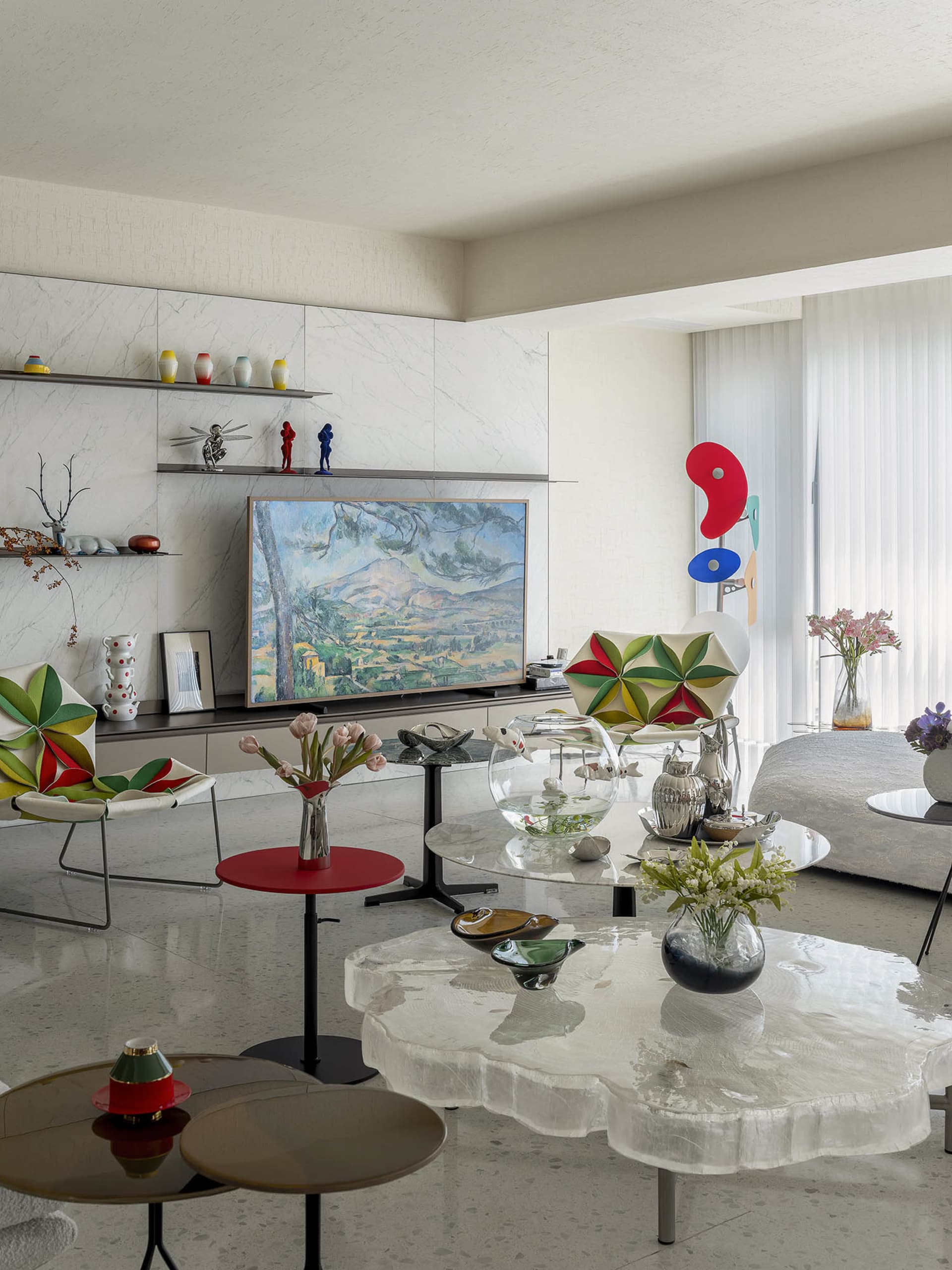 A modern living room featuring glass tables and abstract art.
