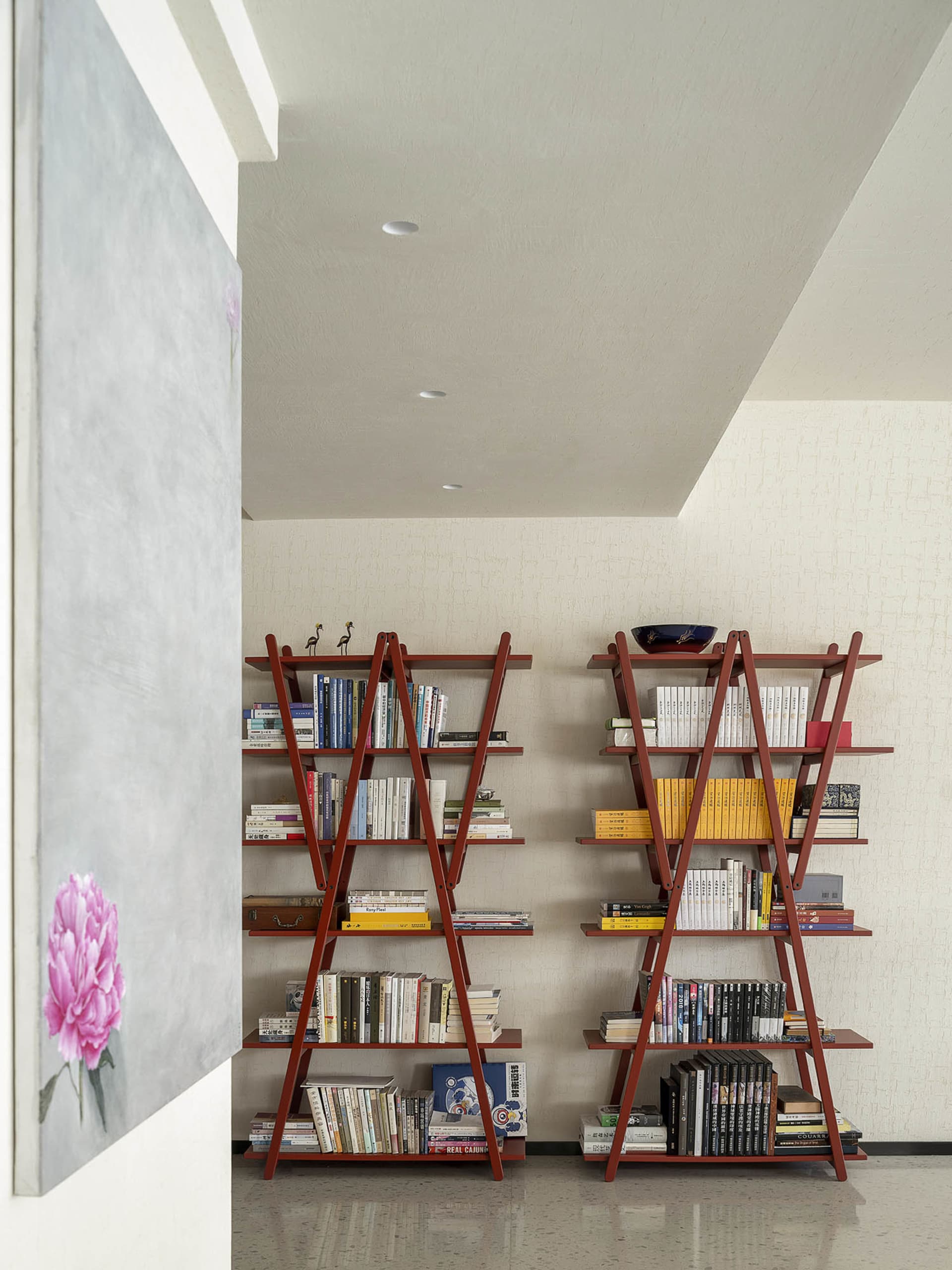 Modern interior design featuring a shelving unit filled with books, placed in a room with a minimalist design aesthetic.