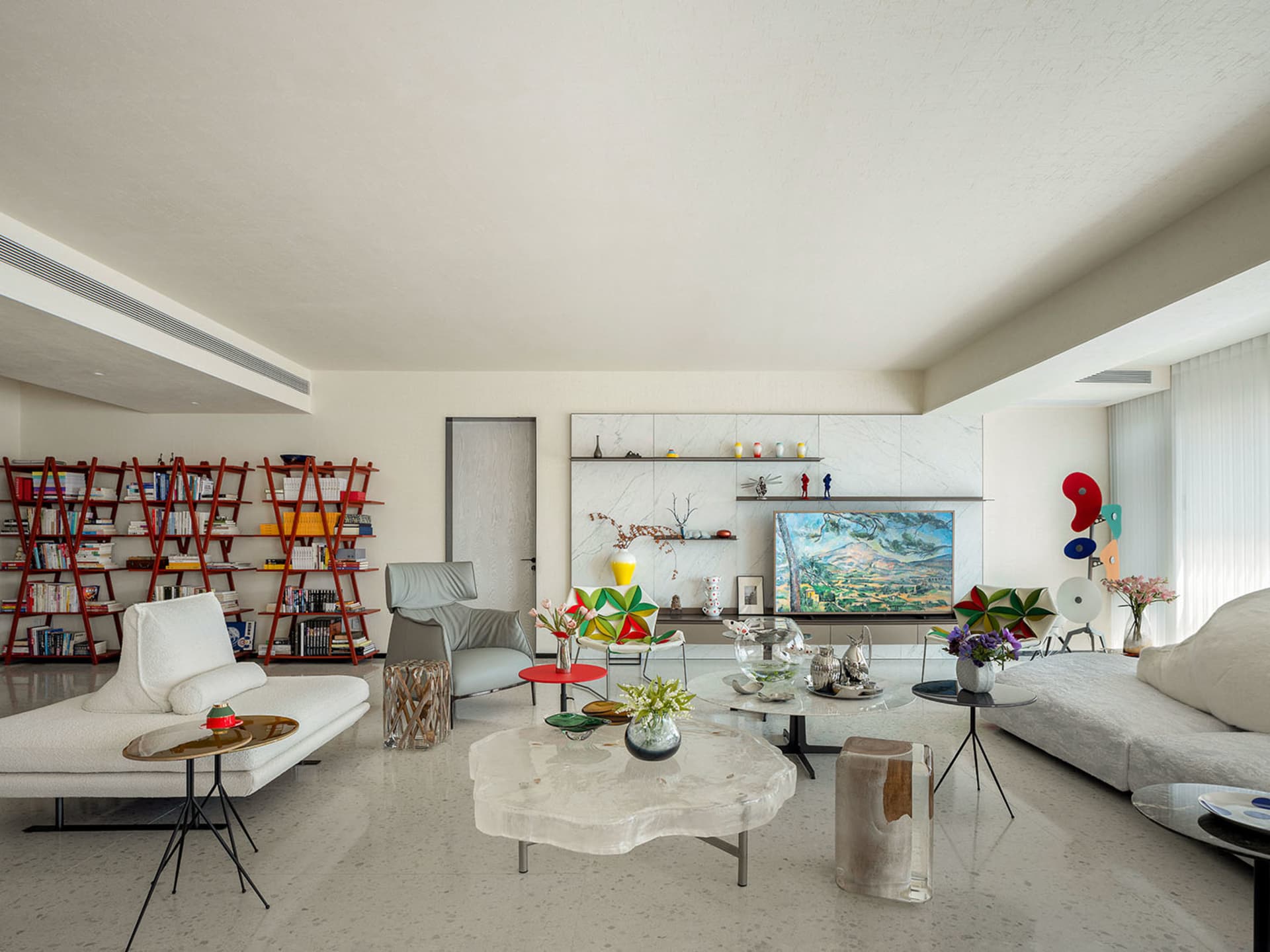 A modern, minimalist living room featuring polished marble accents and abstract art.