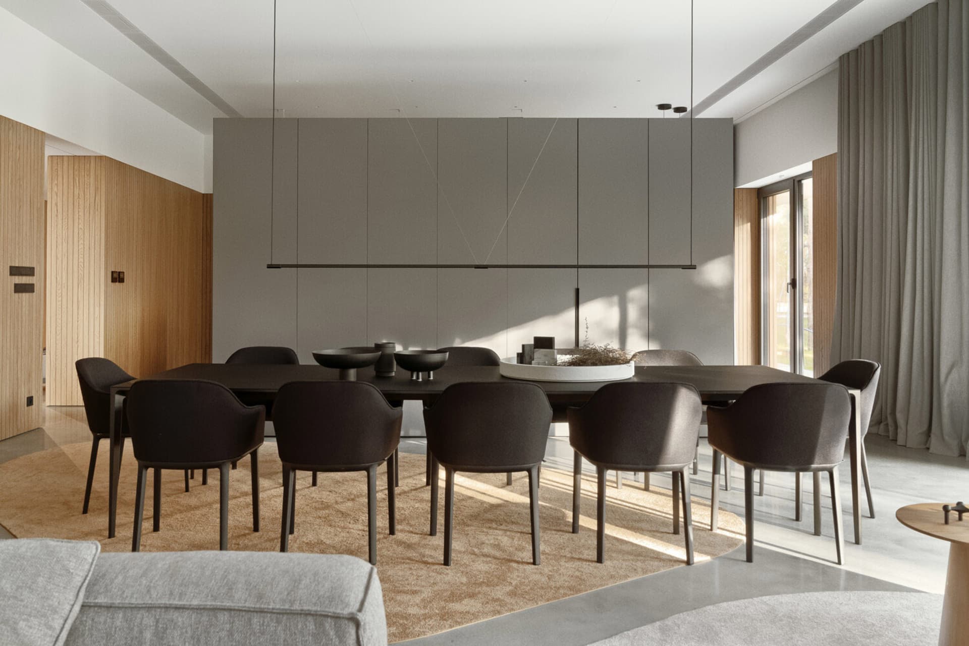 Modern dining room features a concrete flooring paired with wooden furniture.