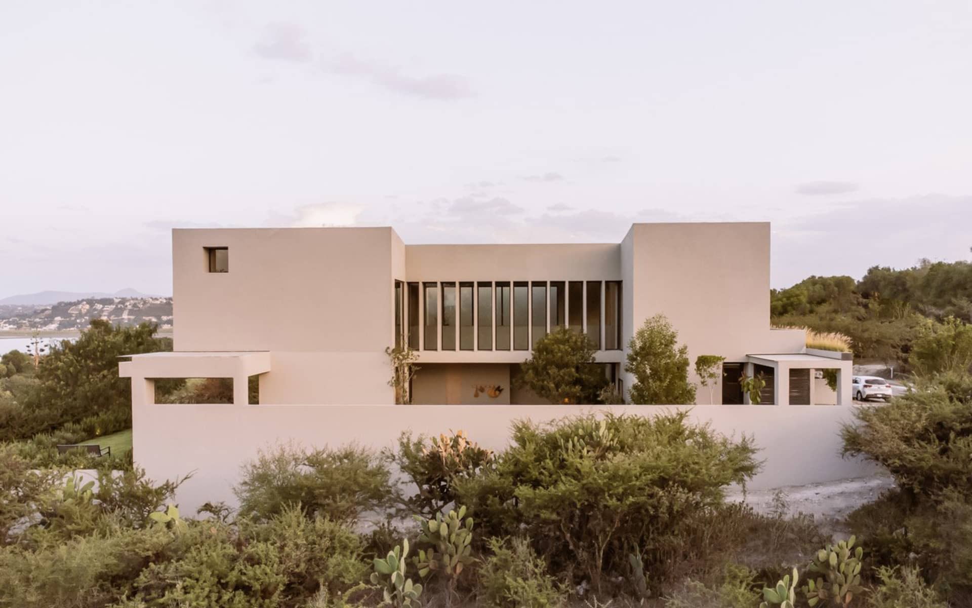 A minimalist modern residence featuring concrete and glass elements.