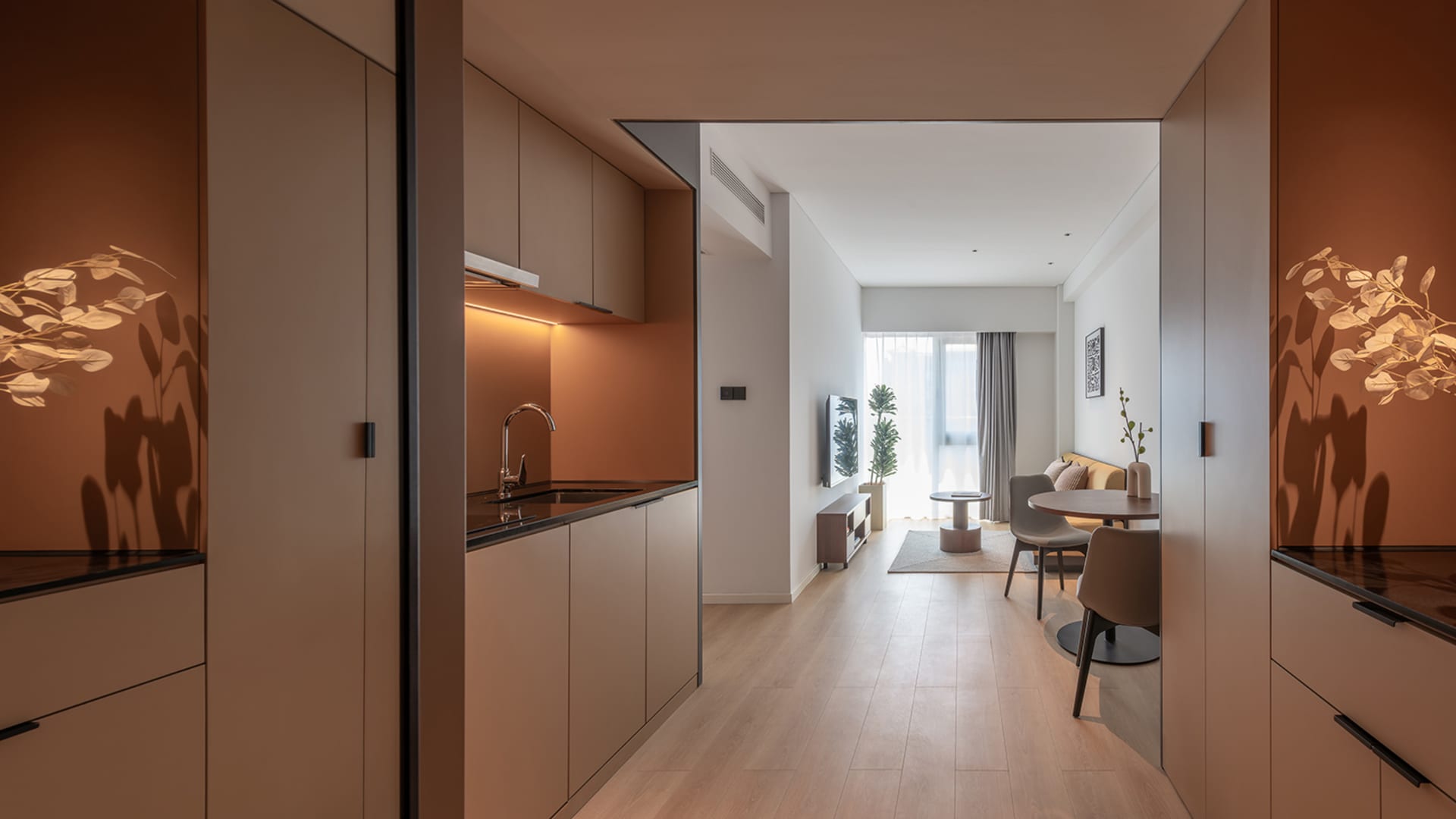 Modern minimalist residential kitchen with terrazzo countertops and warm lighting, showcasing contemporary design features.