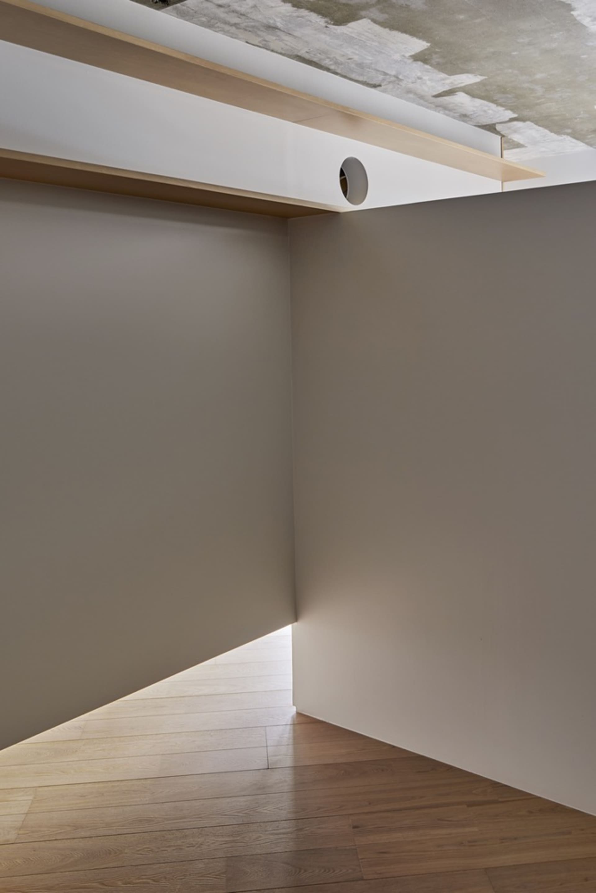 A minimalist interior design featuring a white floor and concrete wall.