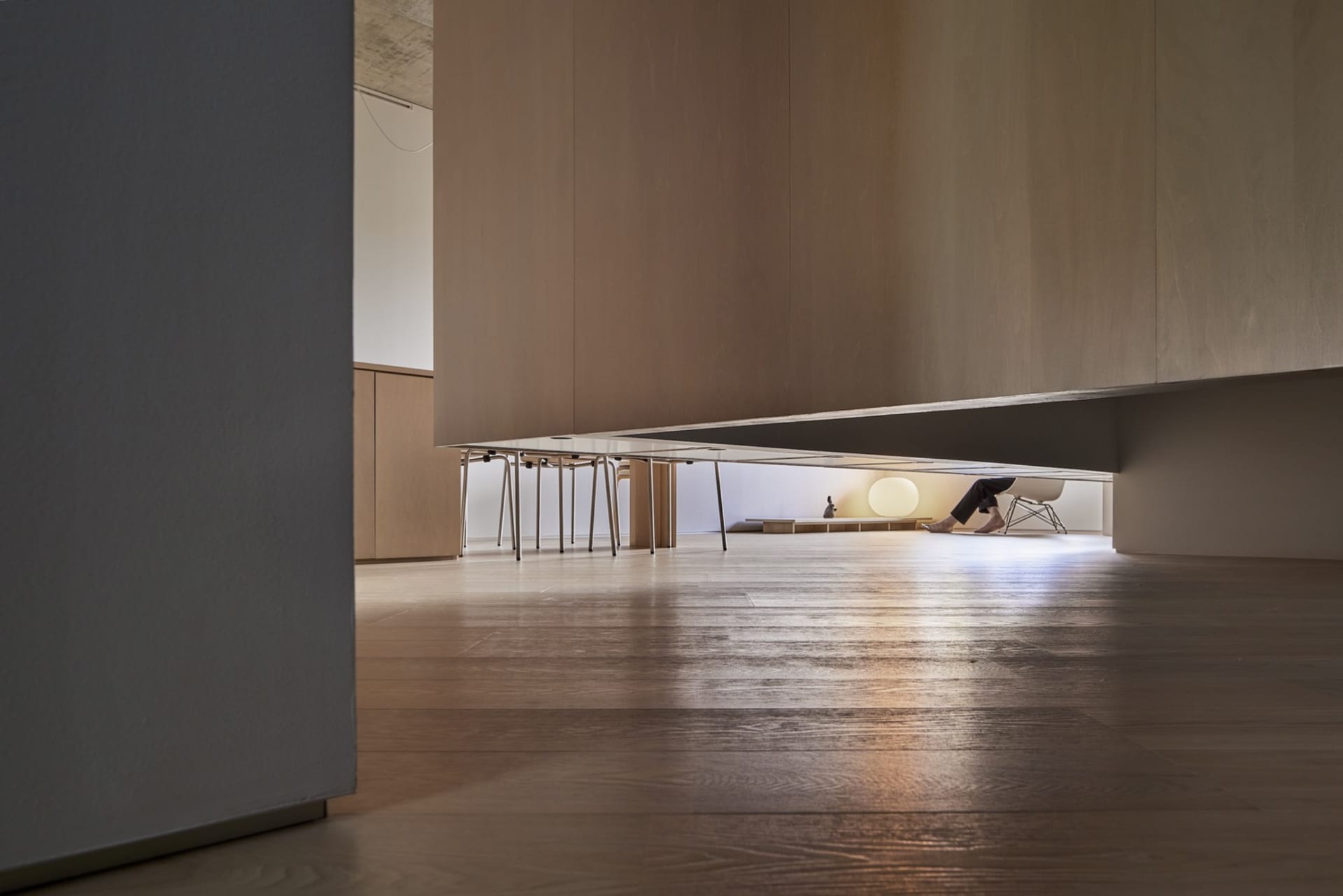 A modern living room featuring minimalist furniture in warm wood tones.