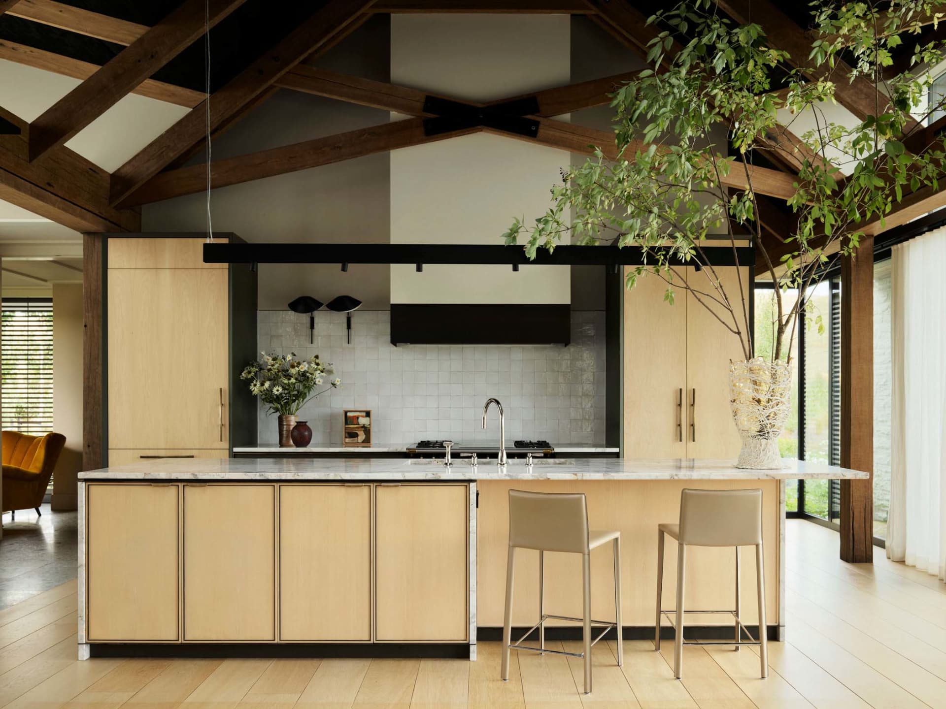 A modern residential kitchen featuring wood cabinetry and a central island.