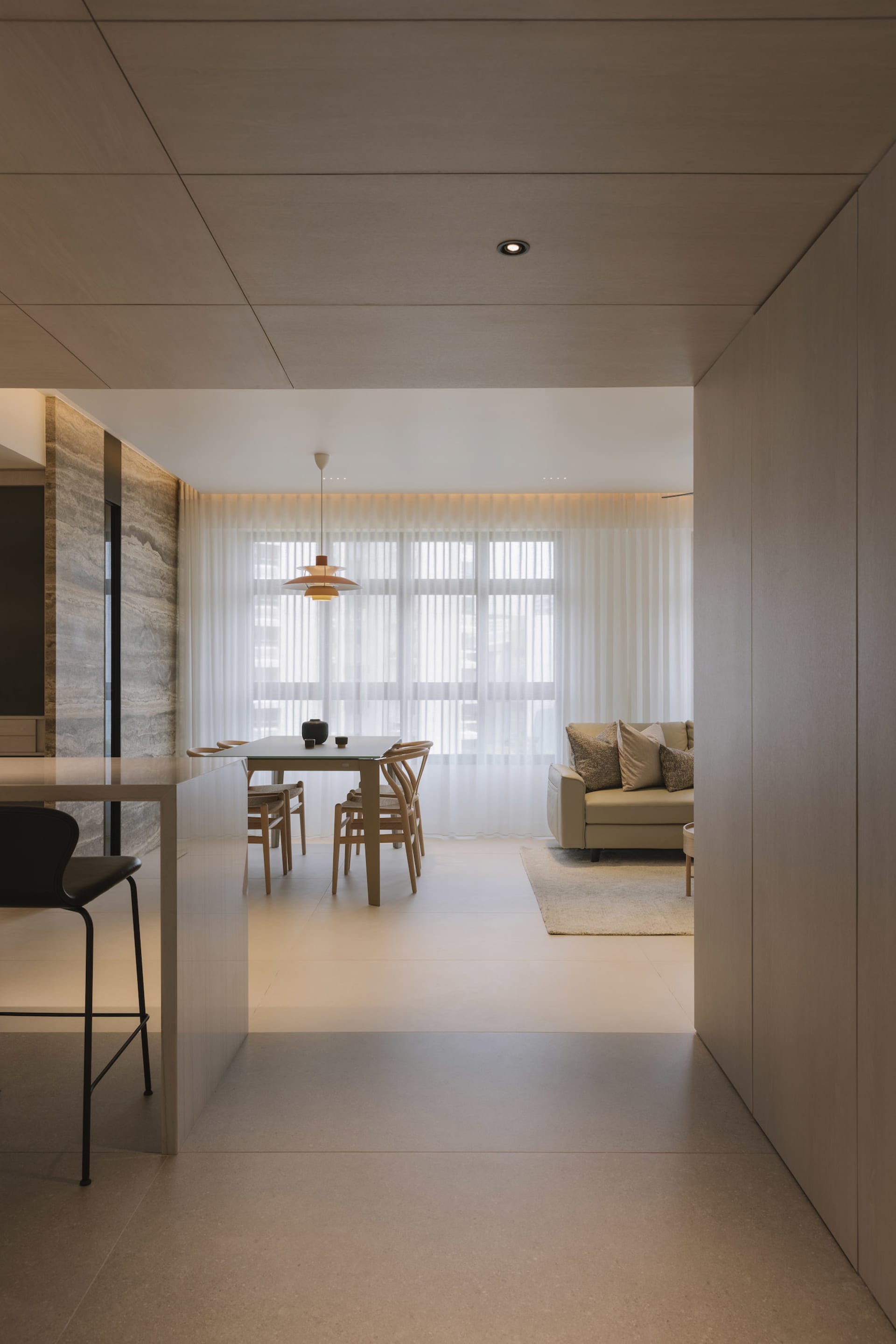 A modern living room with neutral-toned furniture and a large window.